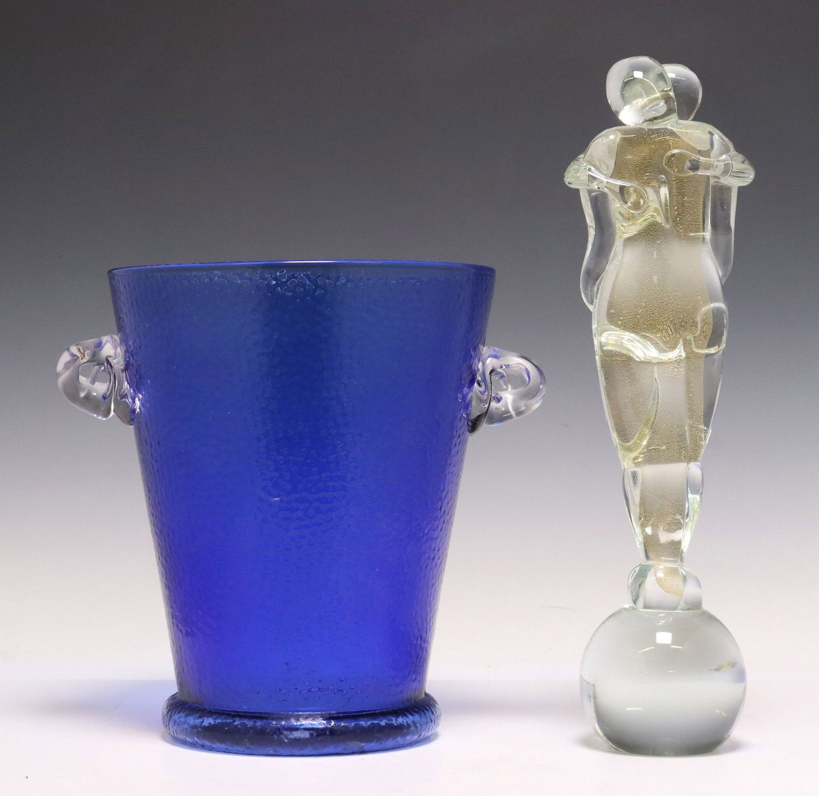(2) MURANO ART GLASS SCULPTURE & CHAMPAGNE BUCKET: (lot of 2) Glass, including: (1) Murano art glass sculpture, colorless glass with gold-colored inclusions, embracing couple standing above a sphere, approx 12.5"h, (1) wine bottle cooler/ ice buc