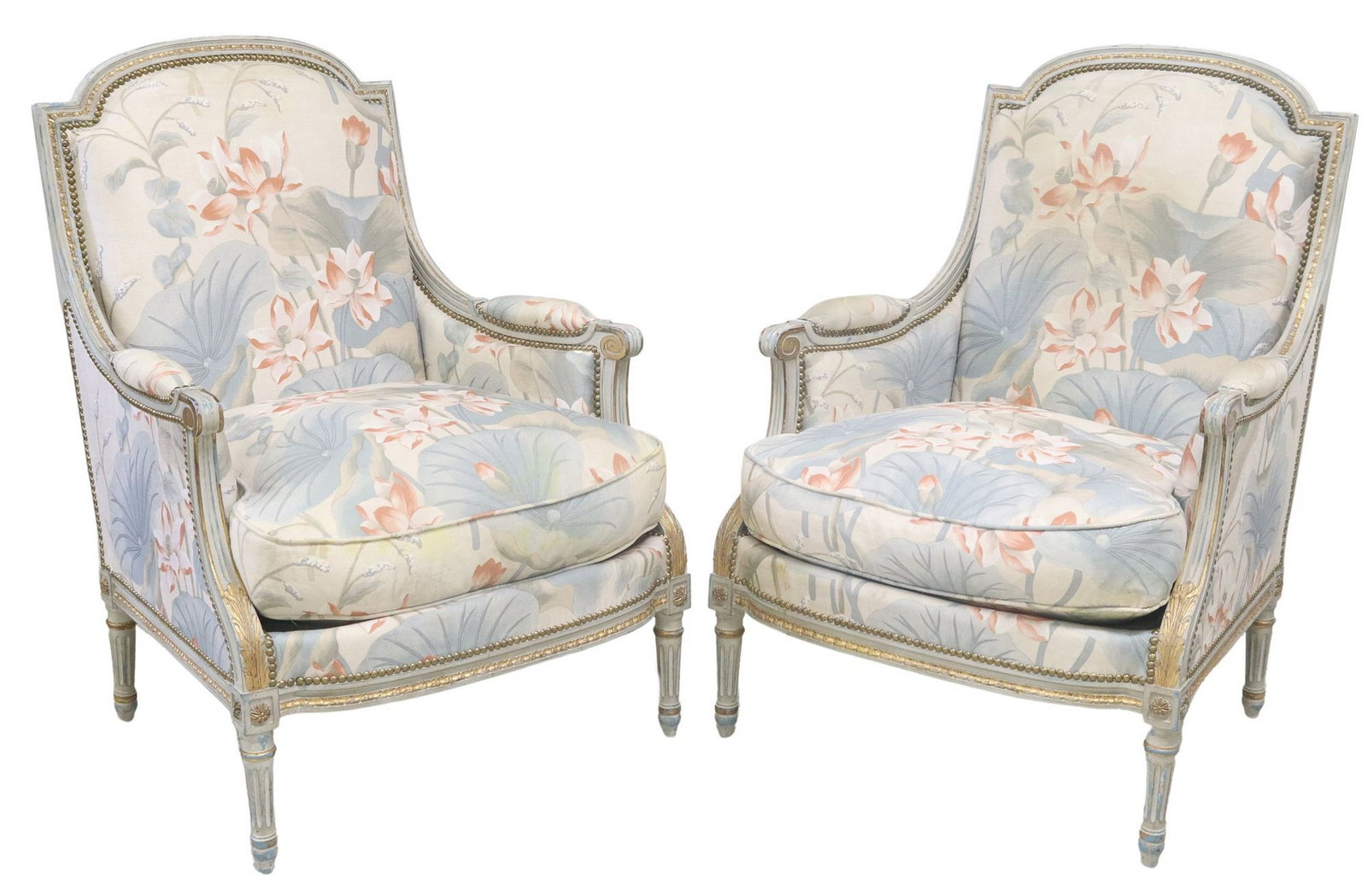 (2) FRENCH LOUIS XVI STYLE PAINTED & PARCEL-GILT BERGERES: (pair) French Louis XVI style armchairs, 20th c., painted and parcel-gilt frame, seat and padded arms in a floral upholstery with nailhead trim, scrolled arms, on fluted tapering legs, approx 39.25&qu