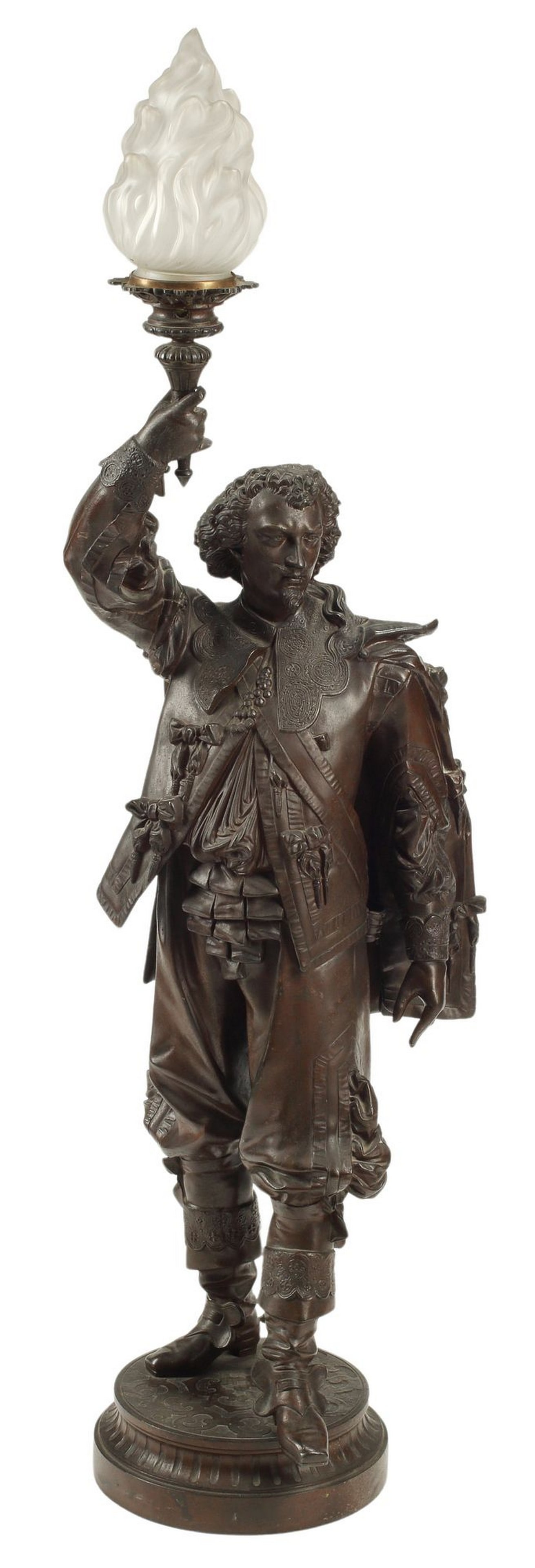 PATINATED METAL FIGURAL TORCHERE: Patinated metal figural torchere, modeled as a cavalier holding aloft a torch, in need of wiring, approx 48"h, 13"w, 10"d