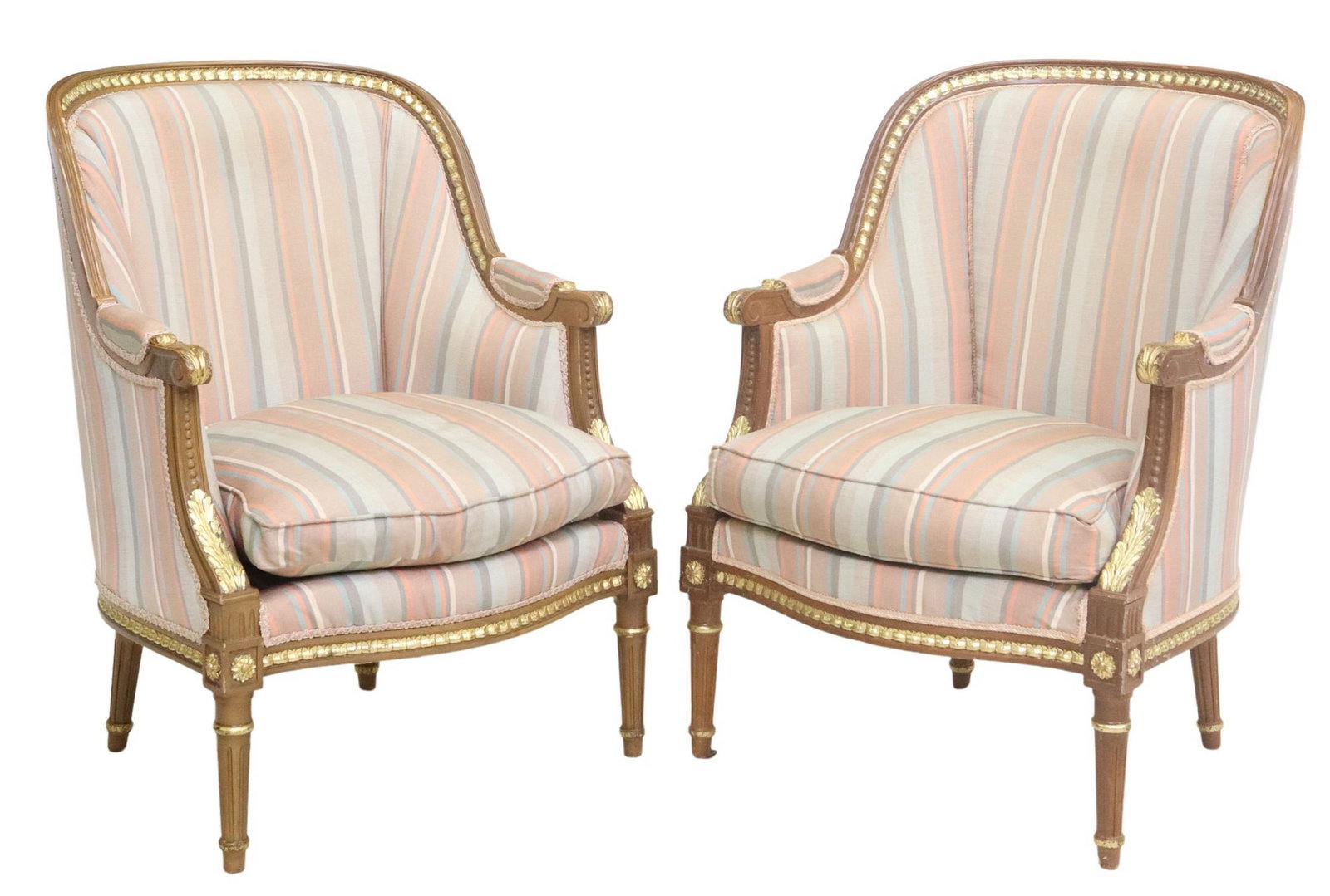 (2) LOUIS XVI STYLE PARCEL GILT UPHOLSTERED BERGERES: (pair) Louis XVI style upholstered bergeres / armchairs, 20th c., having molded frame with parcel gilt accents, rounded back and arms, removable seat cushion, in striped fabric upholstery, with r