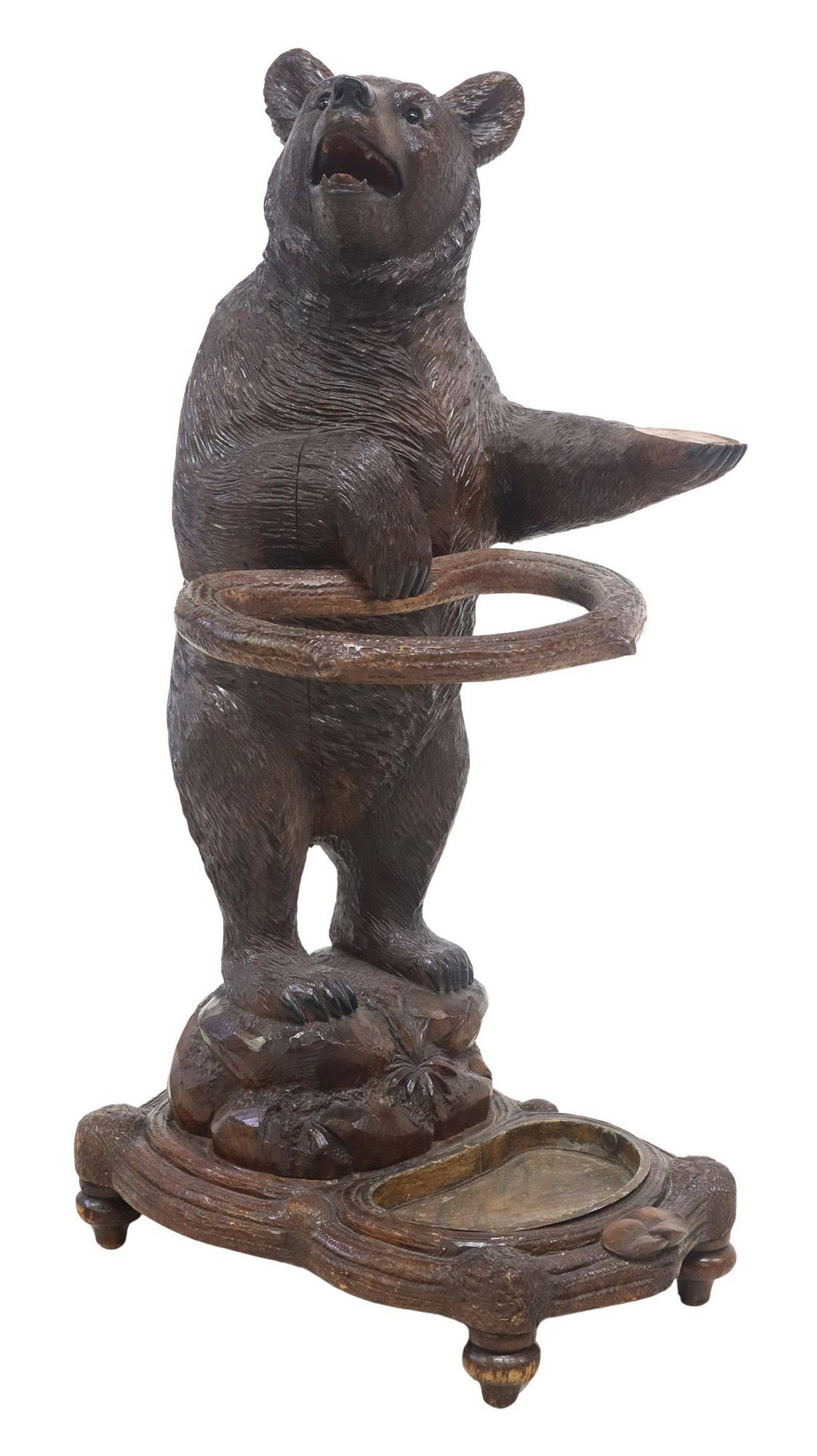 EXCEPTIONAL BLACK FOREST FINELY CARVED BEAR-FORM HALL STAND: Black Forest finely carved walnut umbrella/ stick stand, late 19th c., in the form of a standing bear, with mouth agape revealing teeth, inset glass eyes well defined fur, holding branch-form ring wit
