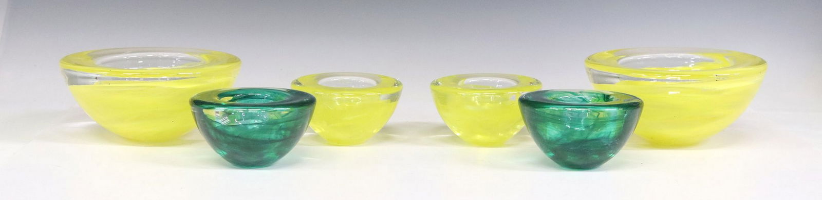 (6) KOSTA BODA 'ATOLL' ART GLASS VOTIVE CANDLEHOLDERS & BOWLS: (lot of 6) Art glass table articles, Anna Ehrner (Swedish, b.1948) for Kosta Boda, Atoll Collection, layered colors of yellow and green within glass, each with maker's mark underfoot, (one)&n