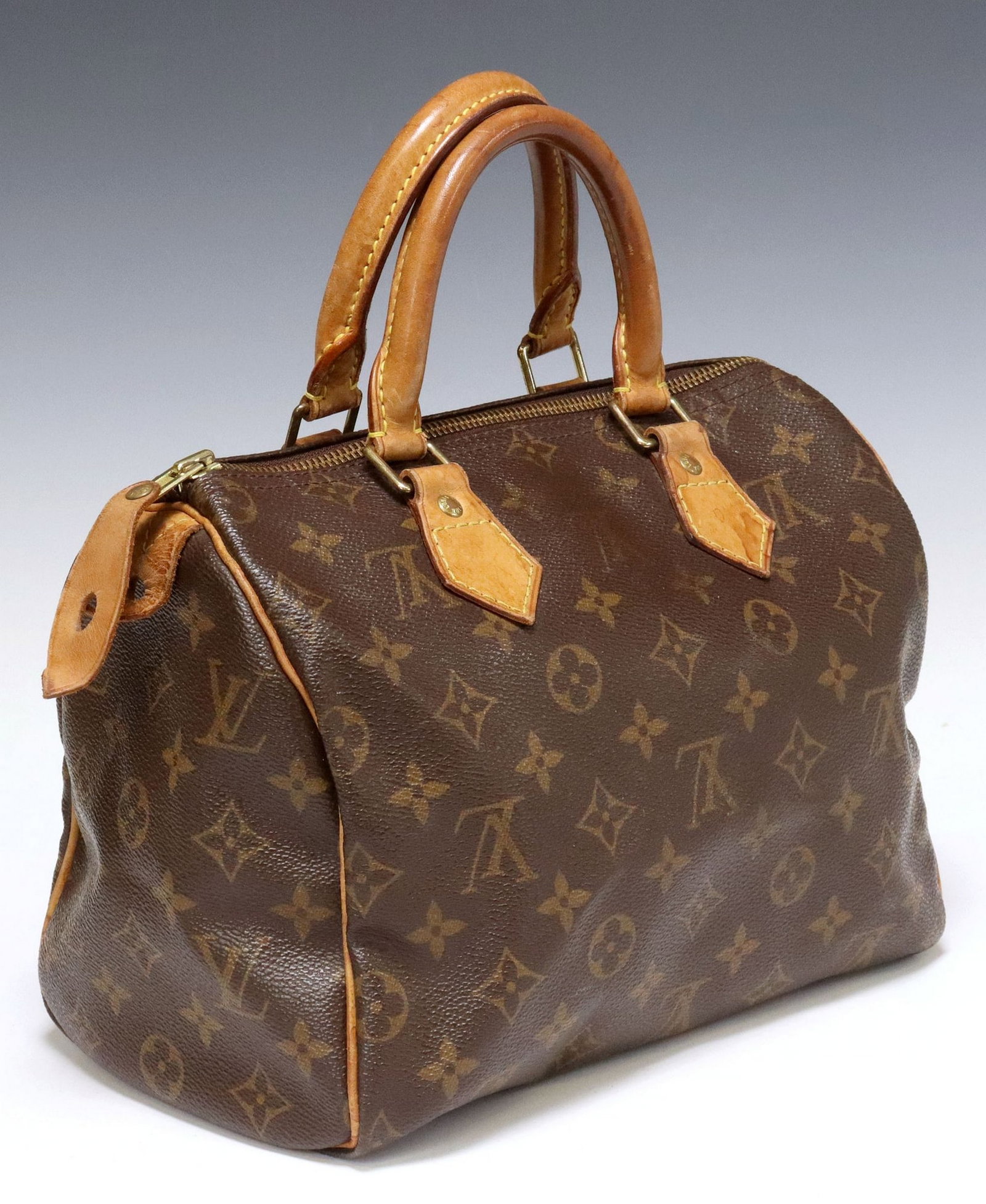LOUIS VUITTON 'SPEEDY 25' BROWN MONOGRAM COATED CANVAS HANDBAG: Louis Vuitton "Speedy 25" handbag, in brown monogram coated canvas, with gold-tone hardware, tan vachetta leather trim, dual rolled handles, top zip closure, opening to brown canvas interior