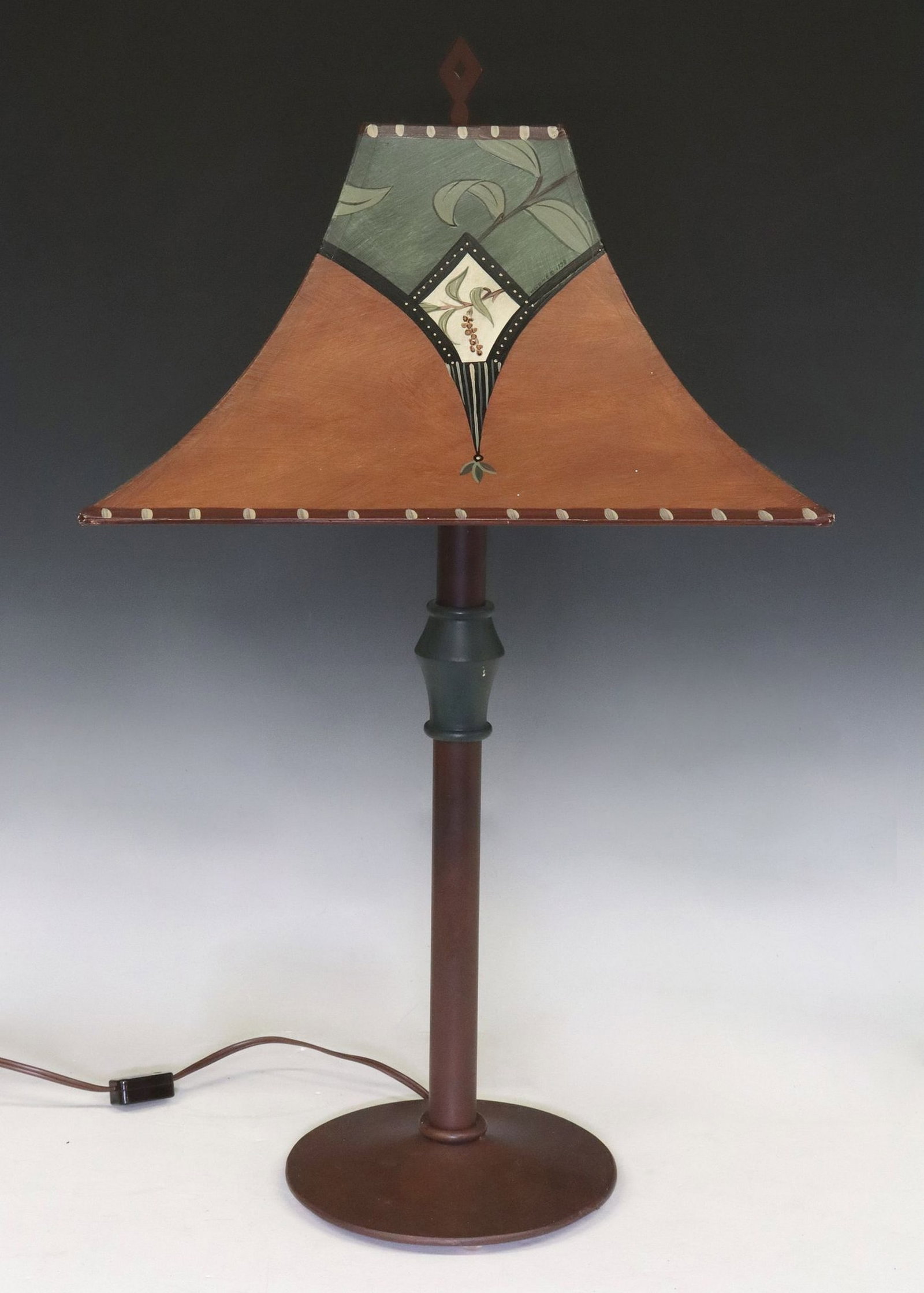 JANNA UGONE CRAFTSMAN-STYLE PAINTED TABLE LAMP: Craftsman-style table lamp, shade signed Ugone (Janna Ugone & Company), dated 1998, painted shade with leaves and berries, on a tole peinte base, overall: approx 25.25"h, 13 7/8"w, 