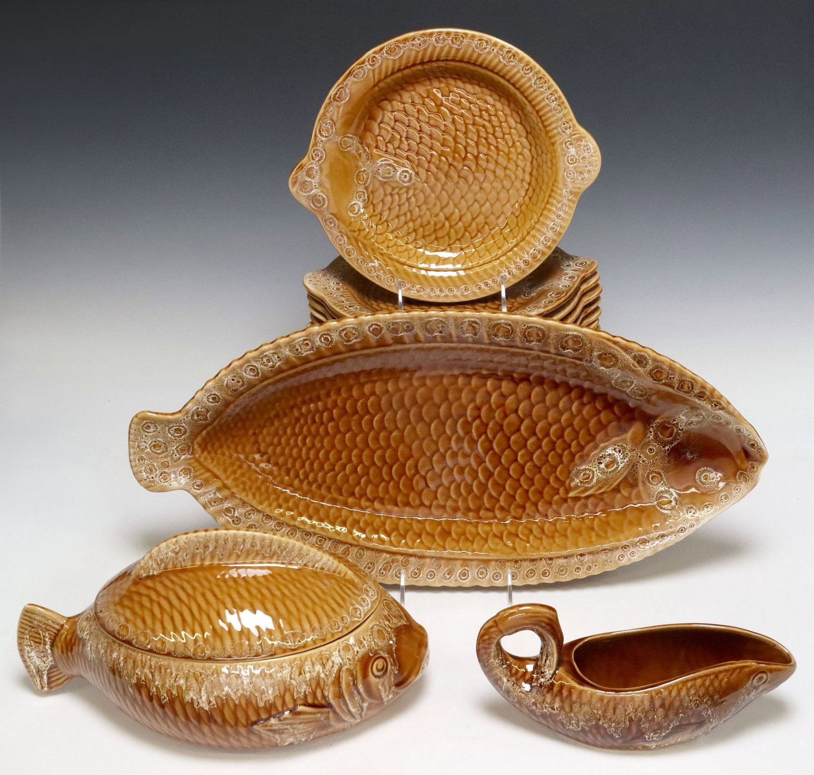 (13) FRENCH SARREGUEMINES FAIENCE FISH SERVICE: (lot of 13) French faience fish service, Sarreguemines, each modeled as a fish with textured scales, in an orange glaze, maker's mark underfoot, including: (10) plates, approx 11"l, 9.5&