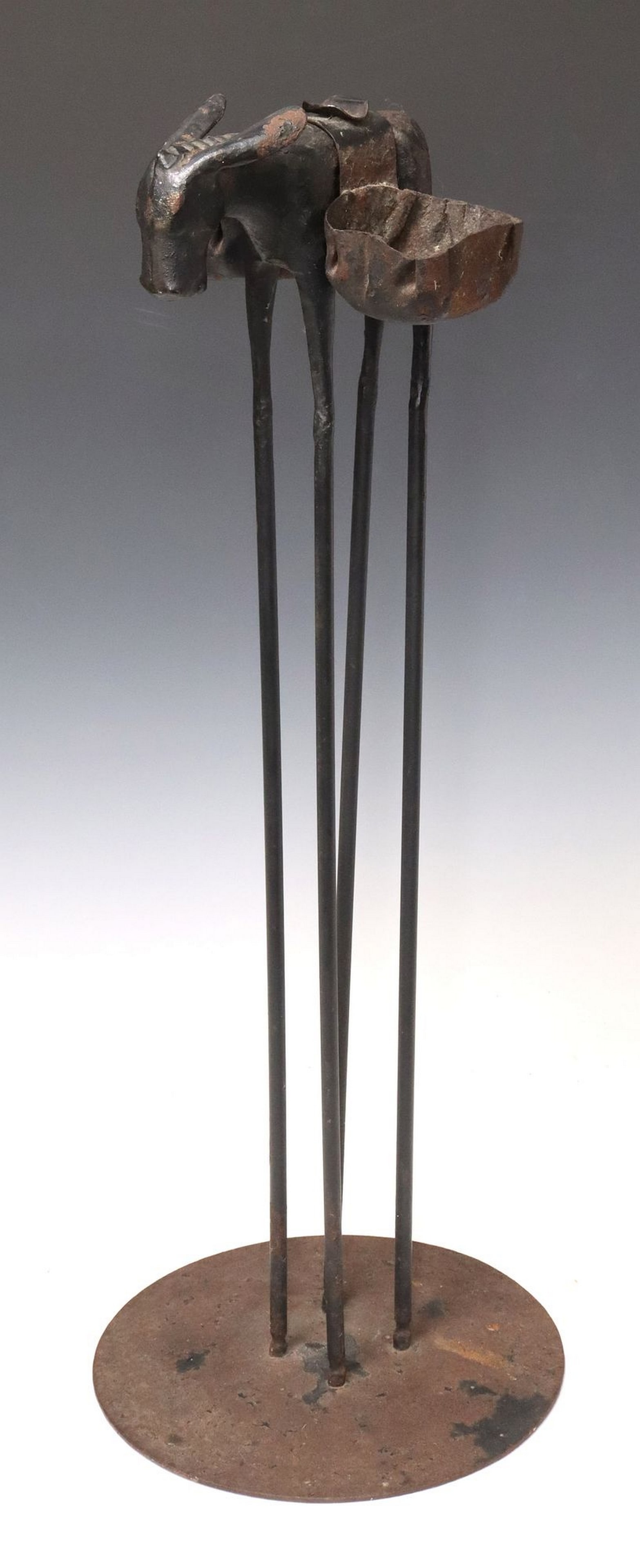 THOMAS MOLESWORTH (1890-1977) WROUGHT IRON BURRO ASHTRAY STAND: Patinated wrought iron sculptural ashtray, Burro, unsigned, attributed to Thomas Molesworth (American, 1890-1977), c. 1938, donkey with removable double-sided ashtray emulating saddle bags, rising on