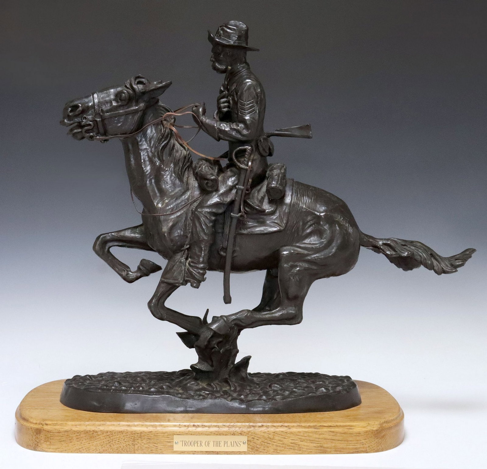 AFTER FREDERIC REMINGTON WESTERN BRONZE 'TROOPER OF THE PLAINS': Patinated bronze sculpture, "Trooper of the Plains," signed in cast after Frederic Sackrider Remington (American, 1861-1909), originally modeled c.1909, depicting a cavalry soldier on h