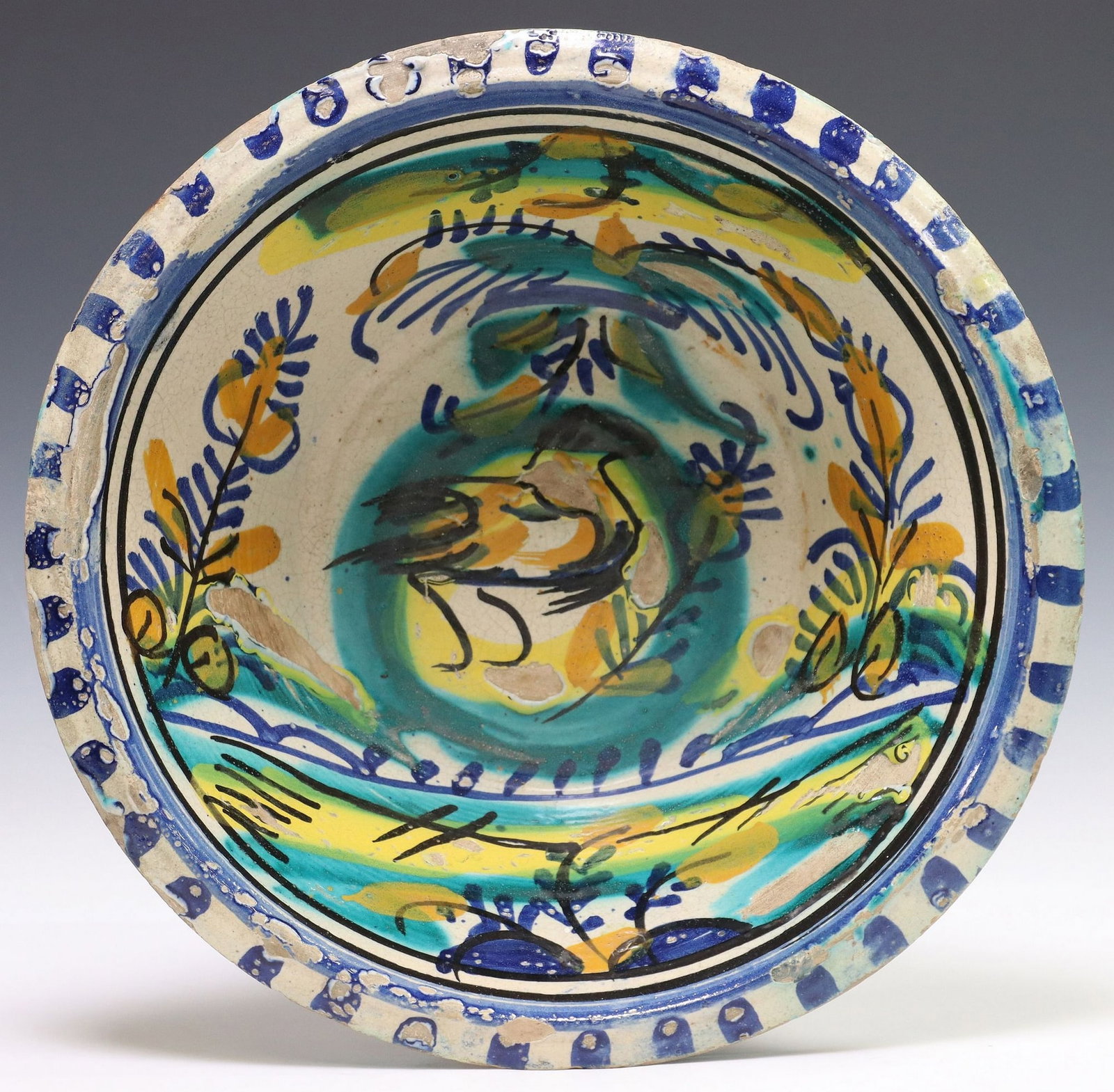 LARGE SPANISH TRIANA GLAZED CERAMIC LEBRILLO BOWL: Large tin-glazed earthenware lebrillo/ basin, Triana, Seville, Spain, painted border, center design of a bird, typical glaze losses and small chips, approx 4.75"h, 14.25"diam, 5.75lbs&n