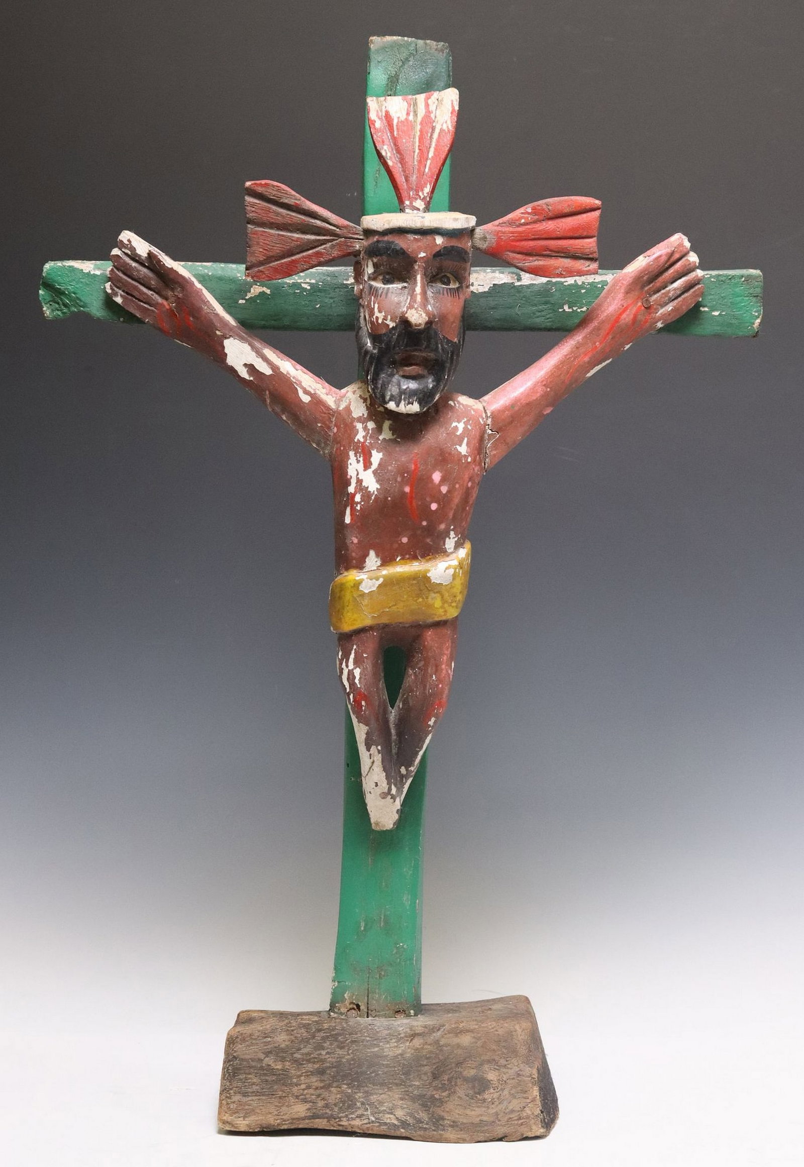 NEW MEXICO STYLE FOLK ART CARVED & PAINTED ALTAR CRUCIFIX: New Mexico style folk art carved wood altar crucifix, depicting Corpus Christi with protruding crown and bloody stigmata, worn polychrome painted finish, rising on naturalistic wood base, approx 26&qu