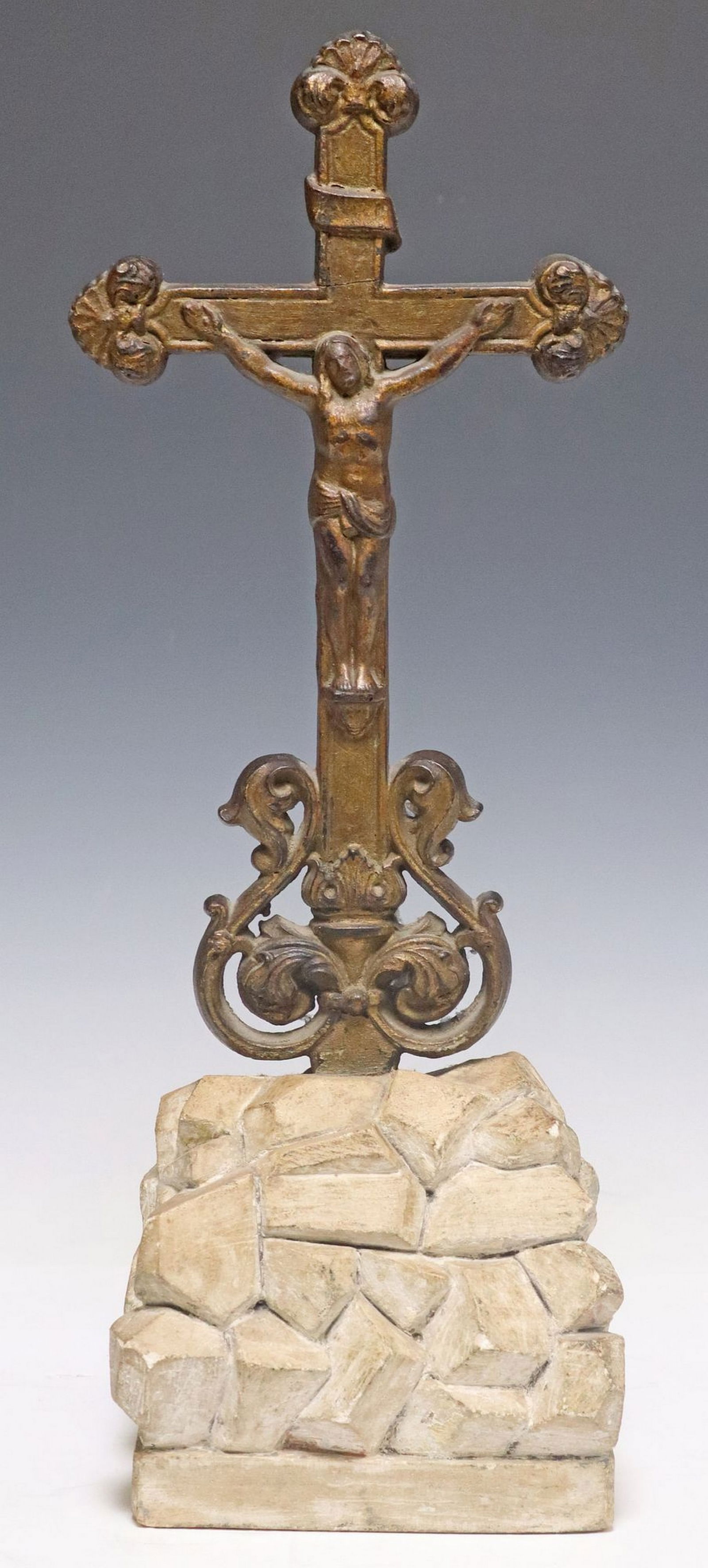 GILT-PAINTED CAST IRON CRUCIFIX ON ALABASTER ROCAILLE BASE: Gilt-painted cast iron crucifix, on a carved alabaster naturalistic rocky base, approx 17.75"h, 6.75"w, 4.5"d, 10.5lbs