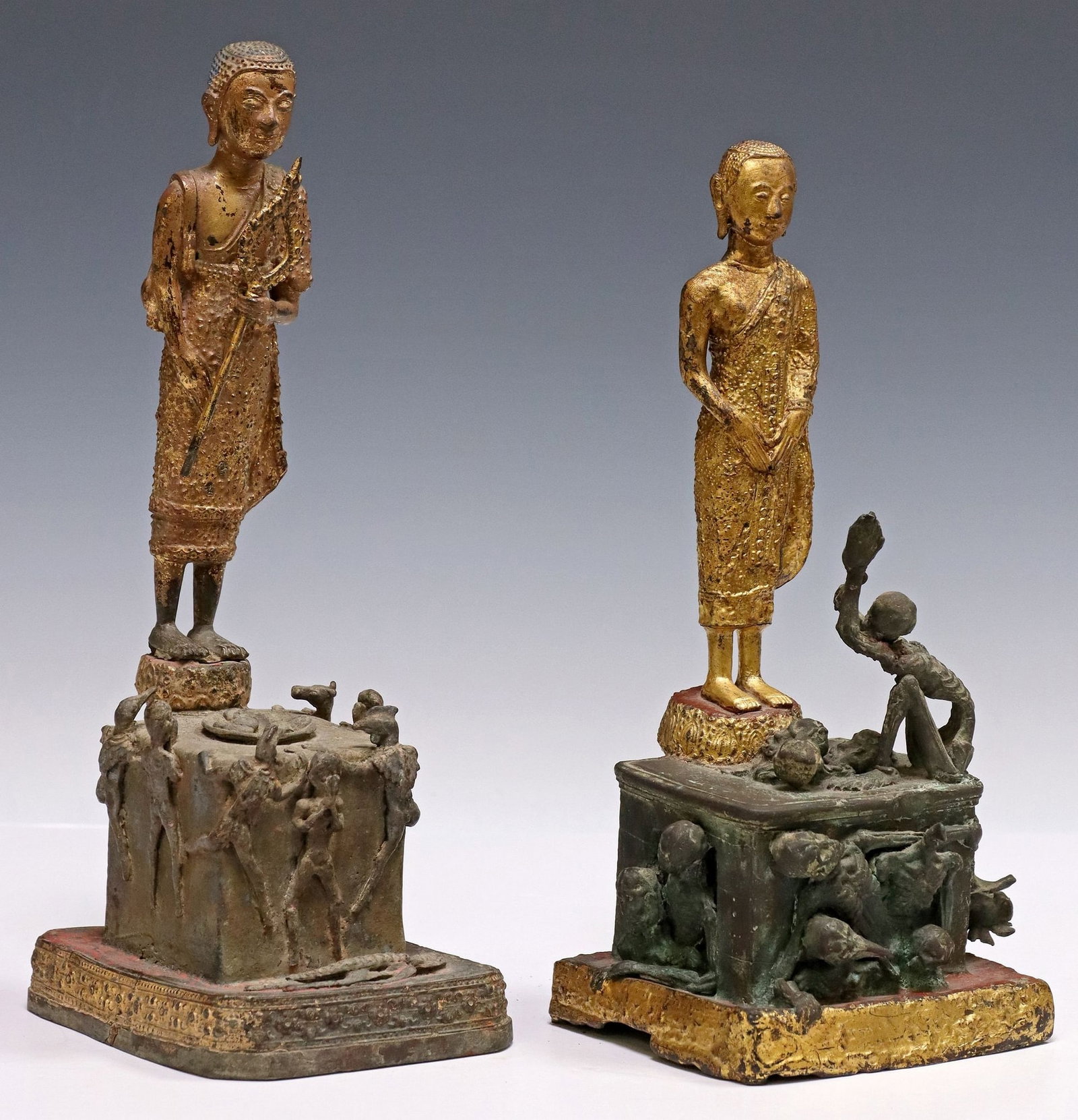 (2) SOUTHEAST ASIAN PATINATED & GILT METAL FIGURES OF MONK PHRA MALAI: (lot of 2) Southeast Asian patinated and gilt metal figures, each depicting the Monk Phra Malai, standing above square plinth representing hell, lined with skeletal figures in various dynamic poses, l