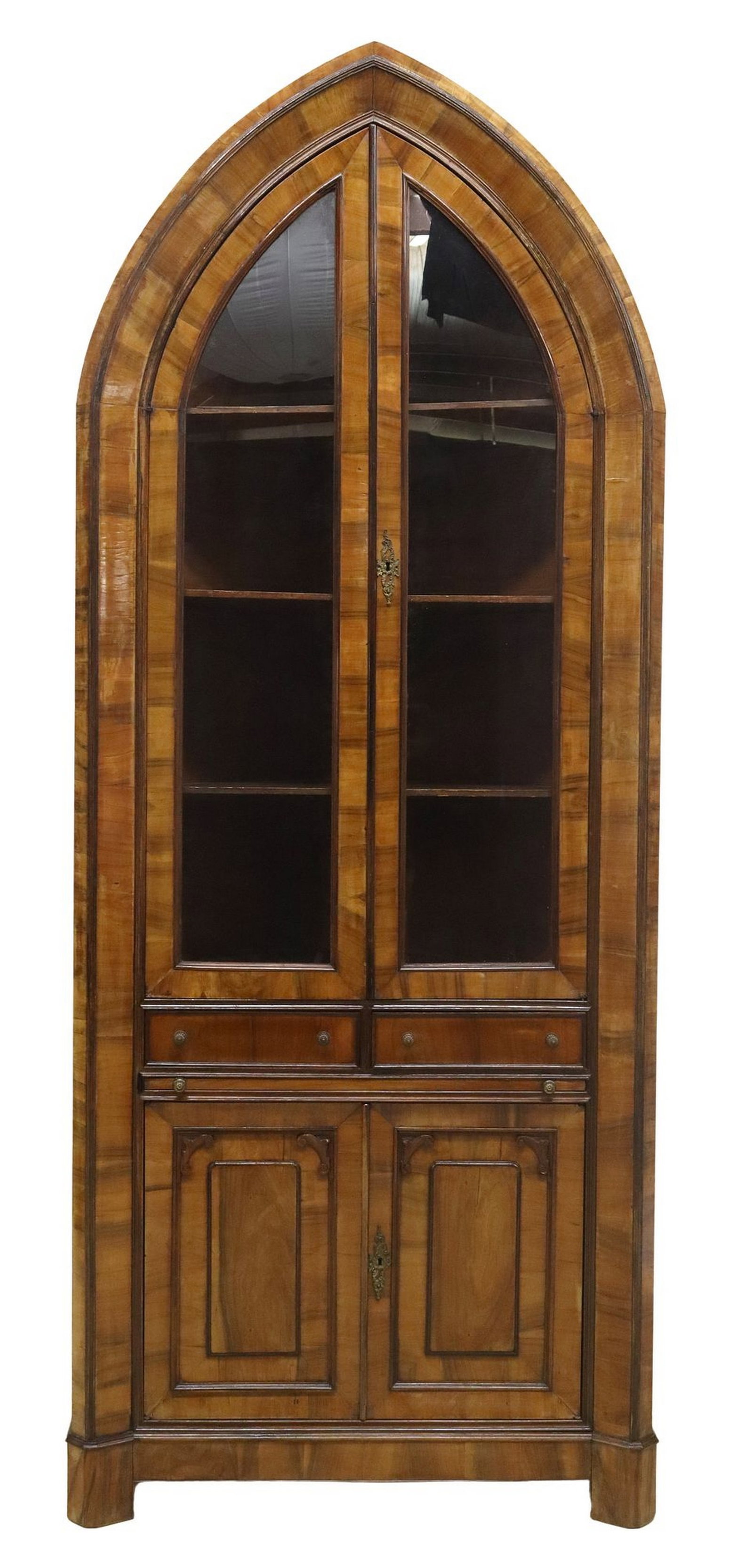 ITALIAN CARVED WALNUT ARCHED CORNER CABINET: Italian carved walnut arched corner cabinet, 19th c., having two glass panel doors, two drawers with on pull front surface, over two additional cabinet doors, shelved interior, rising on shaped base, 
