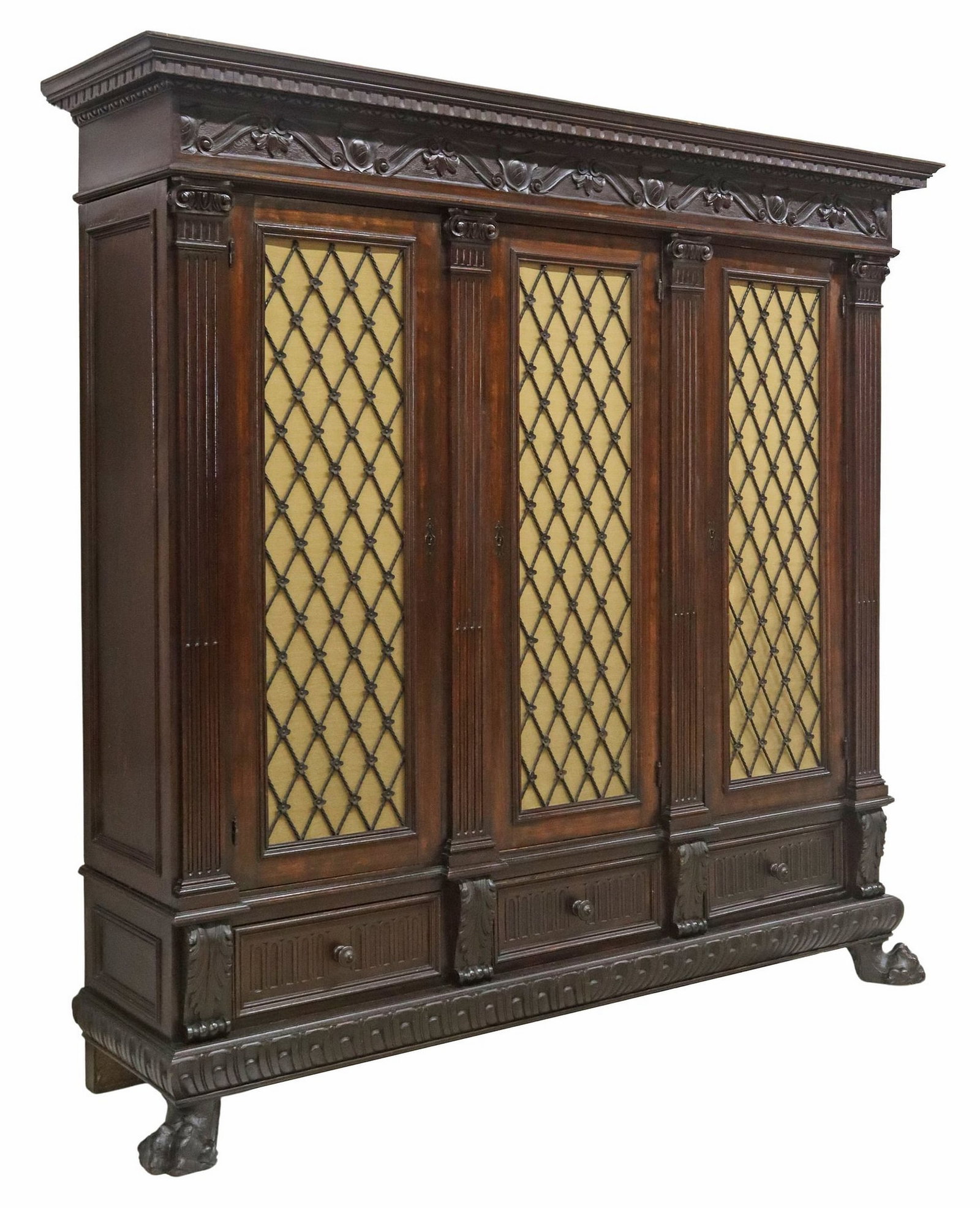 ITALIAN RENAISSANCE REVIVAL CARVED WALNUT BOOKCASE: Italian Renaissance Revival carved walnut bookcase, early 20th c., having stepped cornice, running ornamentation, over three cabinet doors with wright iron panels, revealing shelved interior, flanked 