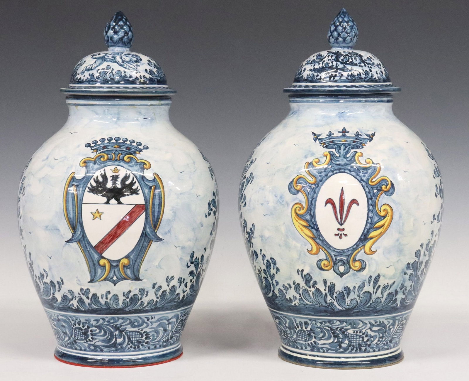 (2) ITALIAN ALBISOLA MAJOLICA TIN-GLAZED POTTERY COVERED URNS: (lot of 2) Italian majolica pottery covered urns, Albisola Superiore, Savona, polychrome tin glazed decoration depicting central heraldic shield and allegorical figure, among foliate scrollwork, 