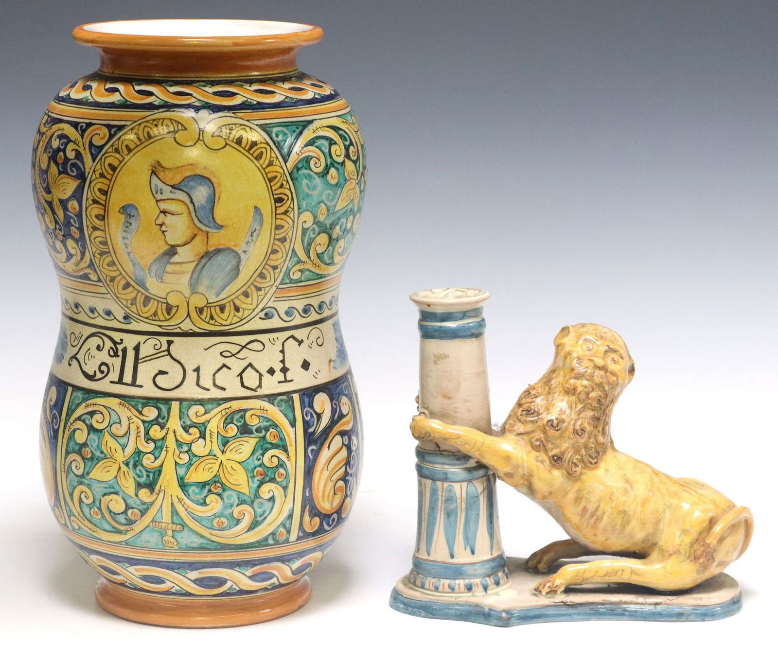 (2) SICILIAN MAJOLICA ALBARELLO & LION CANDLE HOLDER: (lot of 2) Italian majolica, including: (1) albarello/ pharmacy jar, signed underfoot Alemanna Giorgio, Caltagirone, approx 12.25"h, 7"diam, (1) candlestick or spill vase, with a lion s