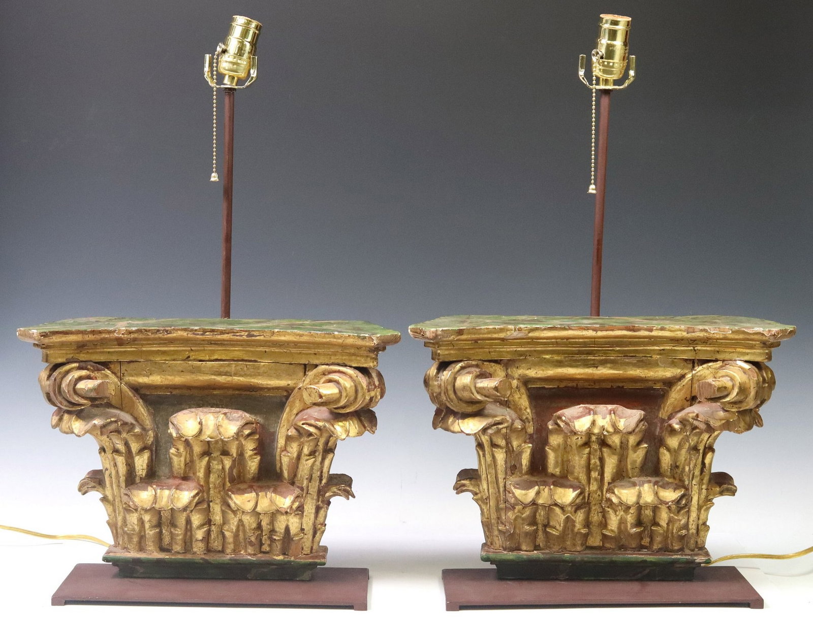(2) ARCHITECTURAL GILTWOOD COMPOSITE ORDER CAPITAL TABLE LAMPS: (lot of 2) Architectural giltwood capital table lamps, having marbleized wood top, carved Composite Order capital, ending on iron base, one lamp with loose top, some gilt loss to both, approx 23"h, 14
