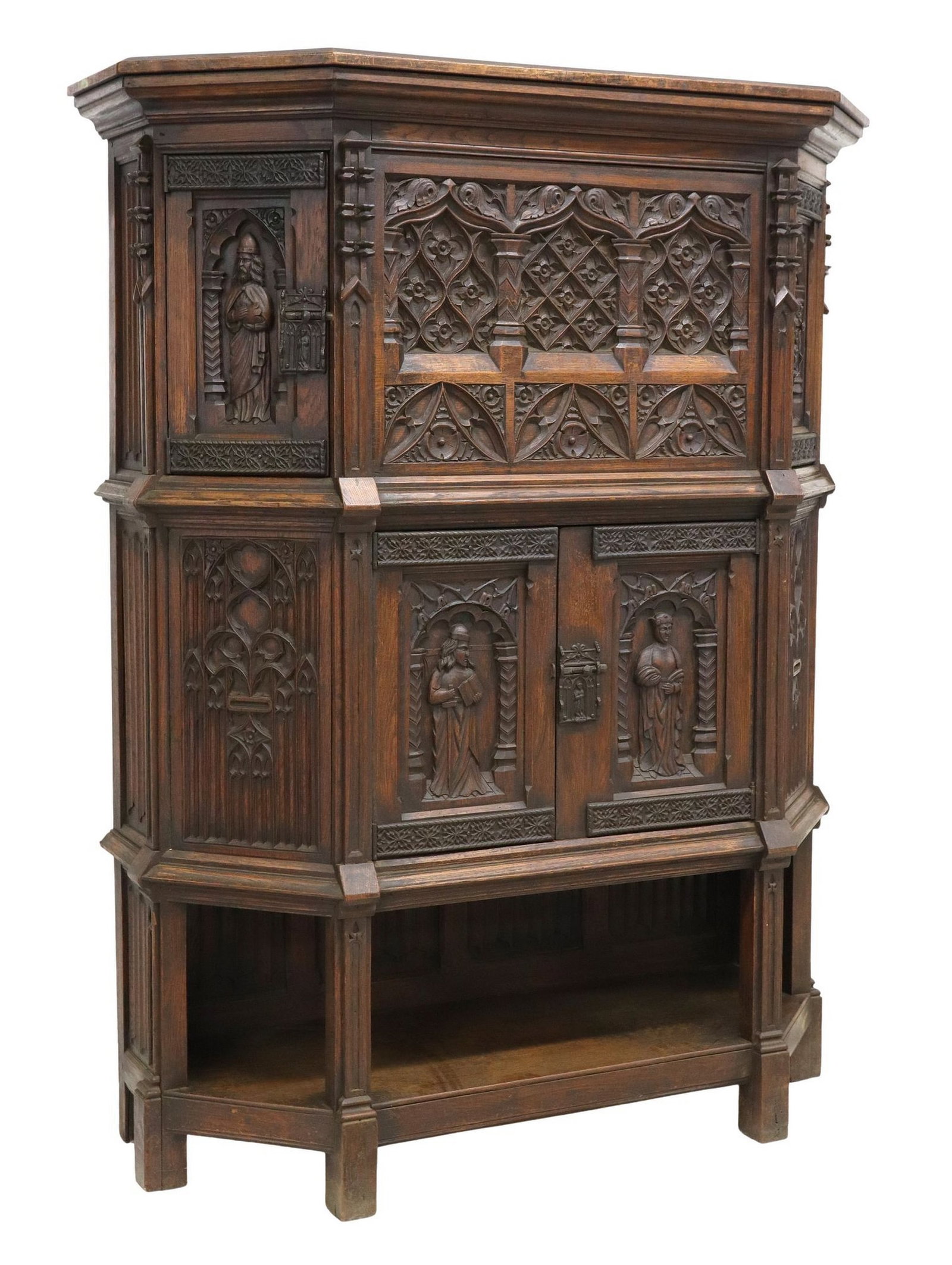 FRENCH GOTHIC REVIVAL CARVED OAK CREDENCE CUPBOARD: French Gothic Revival carved oak credence cupboard, late 19th c., molded cornice, blind tracery center panel, flanked by two upper cabinet doors with figures in architectural niches, lower double-door