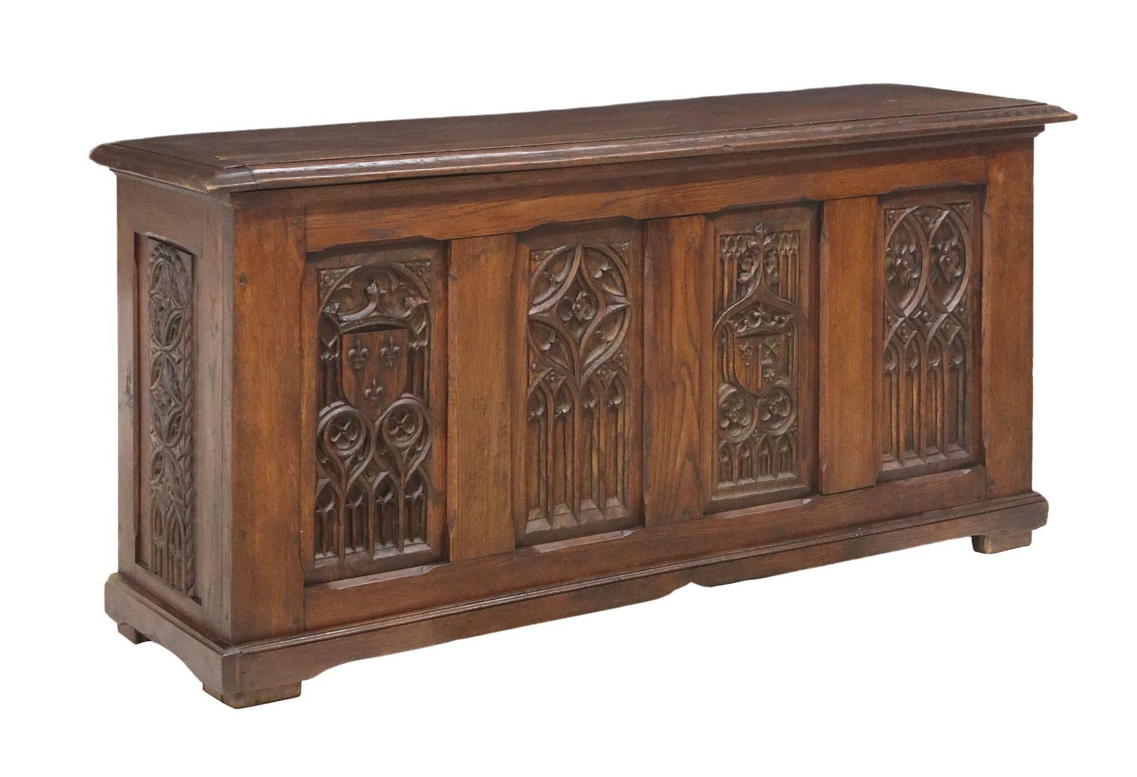 FRENCH GOTHIC REVIVAL CARVED OAK COFFER/ STORAGE CHEST: French Gothic Revival oak coffer/ storage trunk, late 19th c., having rectangular hinged top opening to interior storage, front and side panels with carved tracery and shields, over scalloped apron, r
