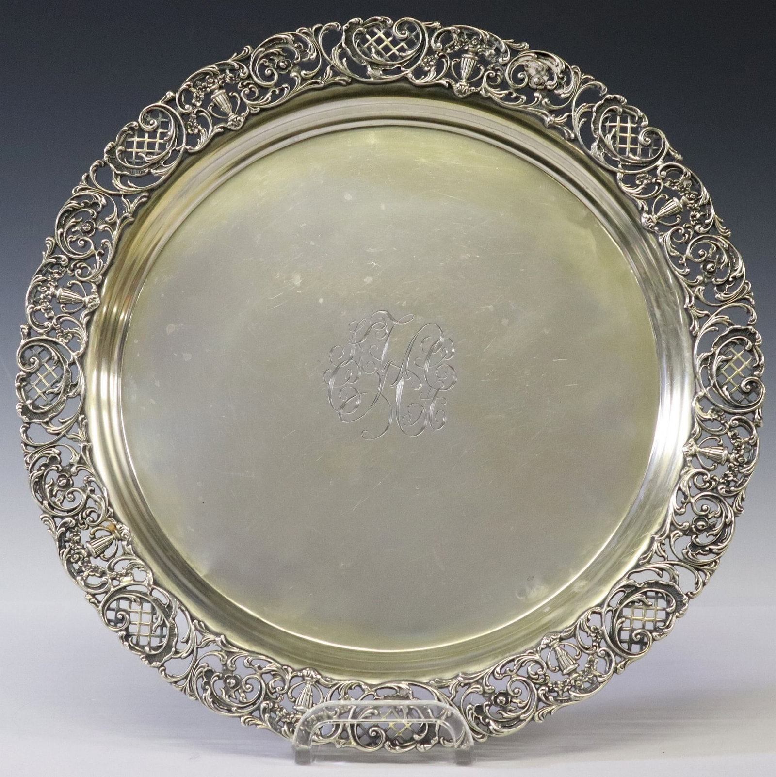 SHREVE & COMPANY STERLING SILVER PIERCED ROUND PRESENTATION TRAY: American sterling silver round tray, Shreve & Company, San Francisco, pierced border with flower-filled urns and lattice c-scrolls, model no. 9821, double monogram, reverse dated 1910 - April