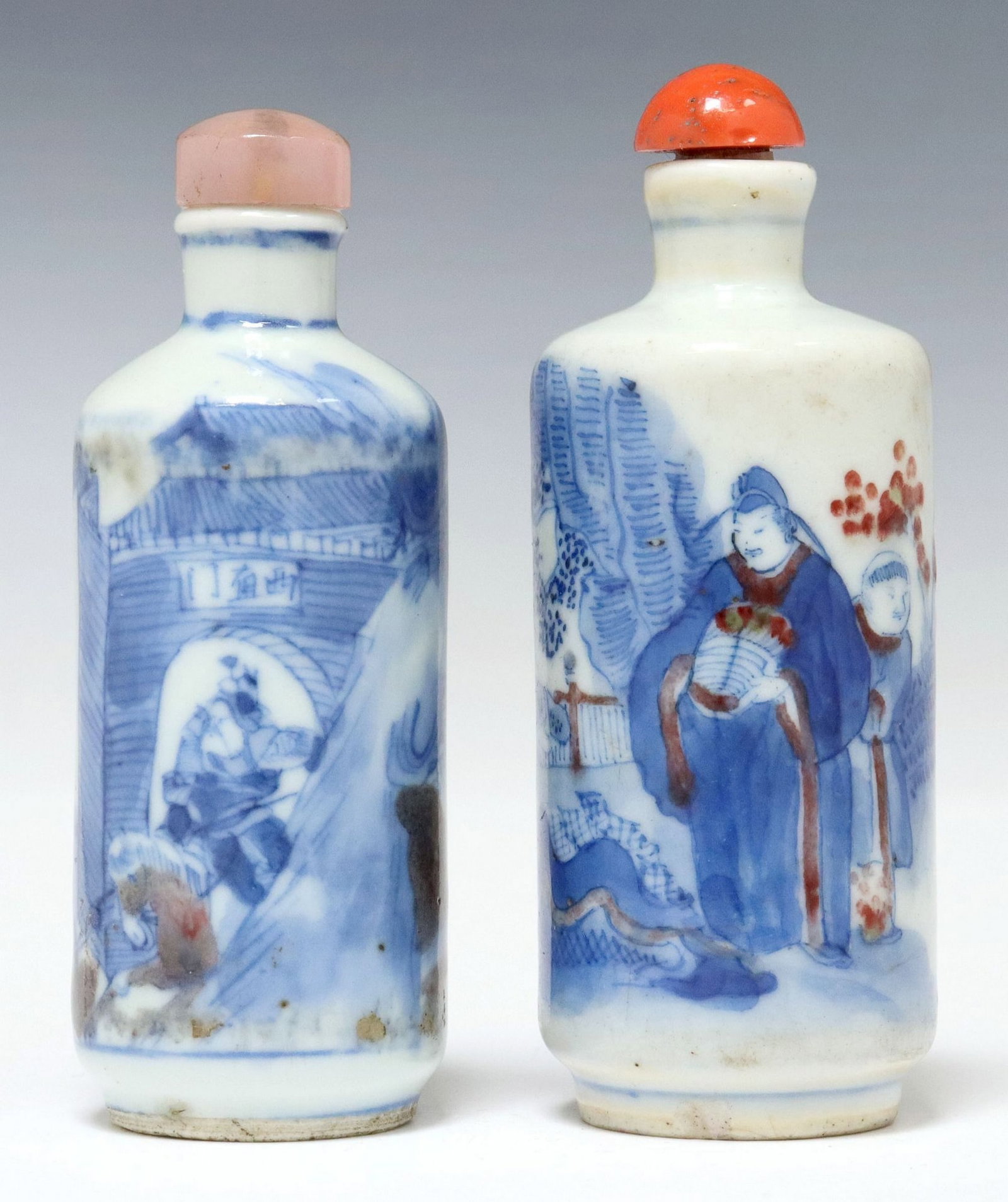 (2) CHINESE BLUE & WHITE PORCELAIN SNUFF BOTTLES WITH STOPPERS: (lot of 2) Chinese blue and white porcelain snuff bottles, each having stopper, with differing scenes of figures in architectural settings, (one) depicting central female beside man pulling cart, pink