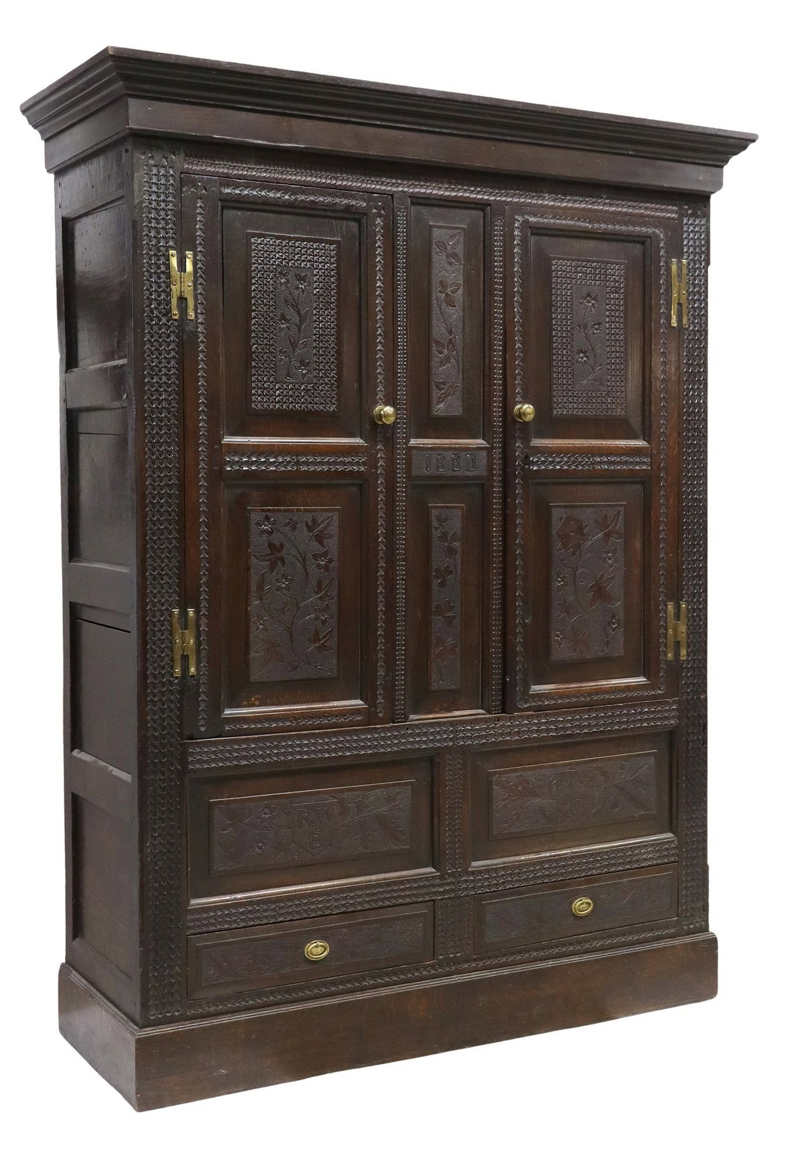 BRITISH TUDOR REVIVAL CARVED OAK LIVERY CUPBOARD DATED 1800: British carved oak livery cupboard, incised date 1800, naturalistic carving, two upper cabinet doors on brass H-shaped hinges, two drawers with carved shields monogrammed RWB, on a plinth ba