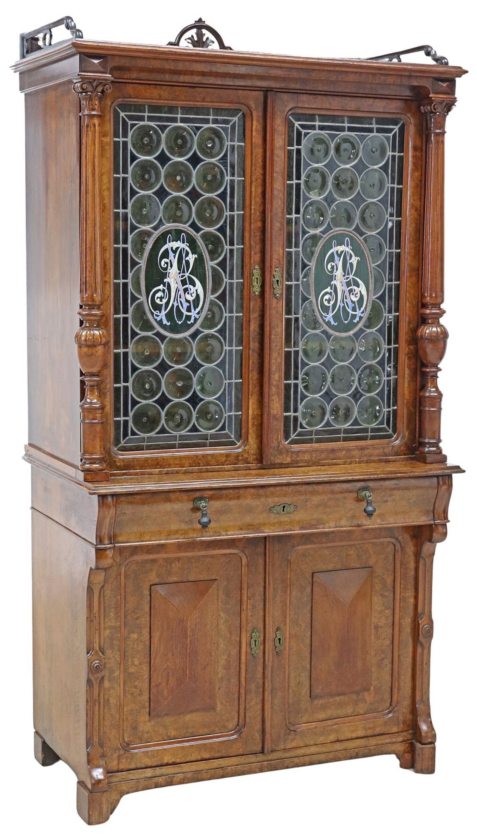HENRI II STYLE BURLWOOD BULLS-EYE GLASS BOOKCASE: Henri II style burlwood bookcase, 19th c., having shaped crest, over two bulls-eye colored glass doors, enameled initials "MB" or "BM," shelved interior, flanked by Corinthian