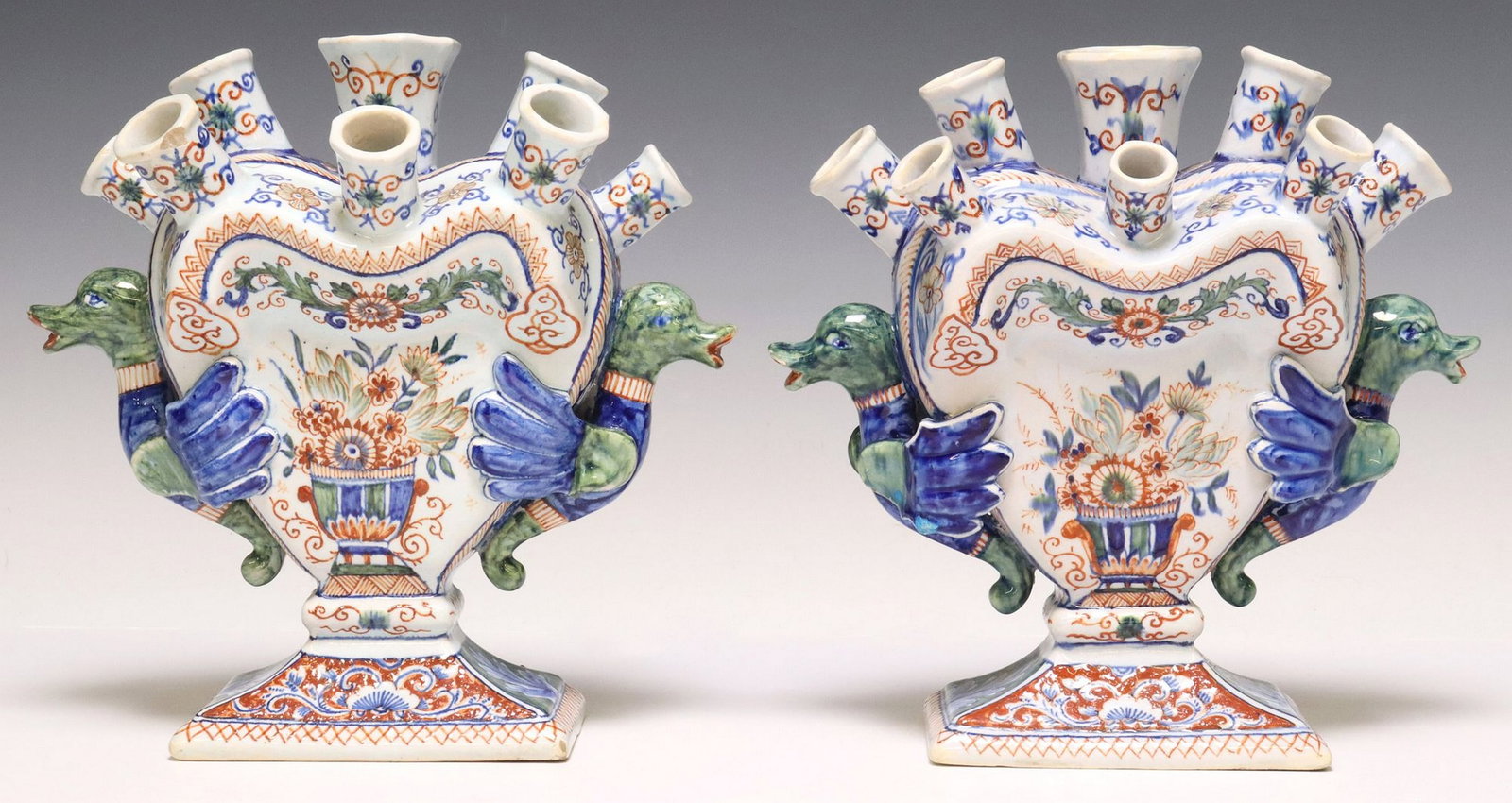 (2) DUTCH DELFT POLYCHROME HEART-SHAPED TULIPIERES: (lot of 2) Dutch Delft tin-glazed earthenware tulipieres/ tulip-holders, eight flower nozzles in two rows, issuing from a flattened heart shape, with polychrome decoration in the "Cashmere" palette of