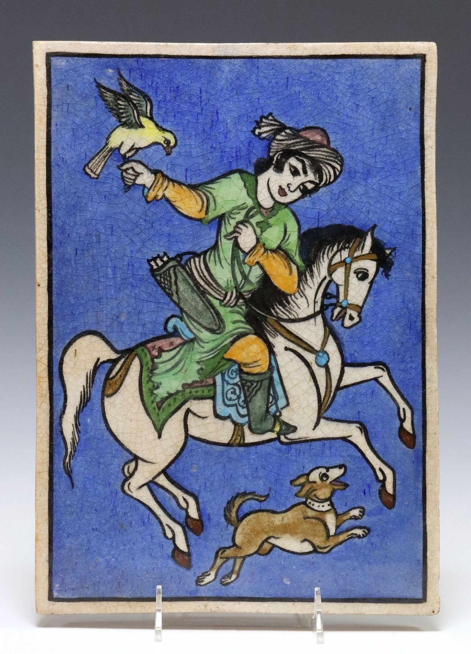LARGE PERSIAN GLAZED POTTERY PICTORIAL TILE, 13.5" X 9.5": Large Persian glazed ceramic pictorial tile, of rectangular form, depicting a mounted horseman with falcon/ hawk, a dog running alongside, against a blue ground, approx 13.5"h, 9.5"w, 5.75lb