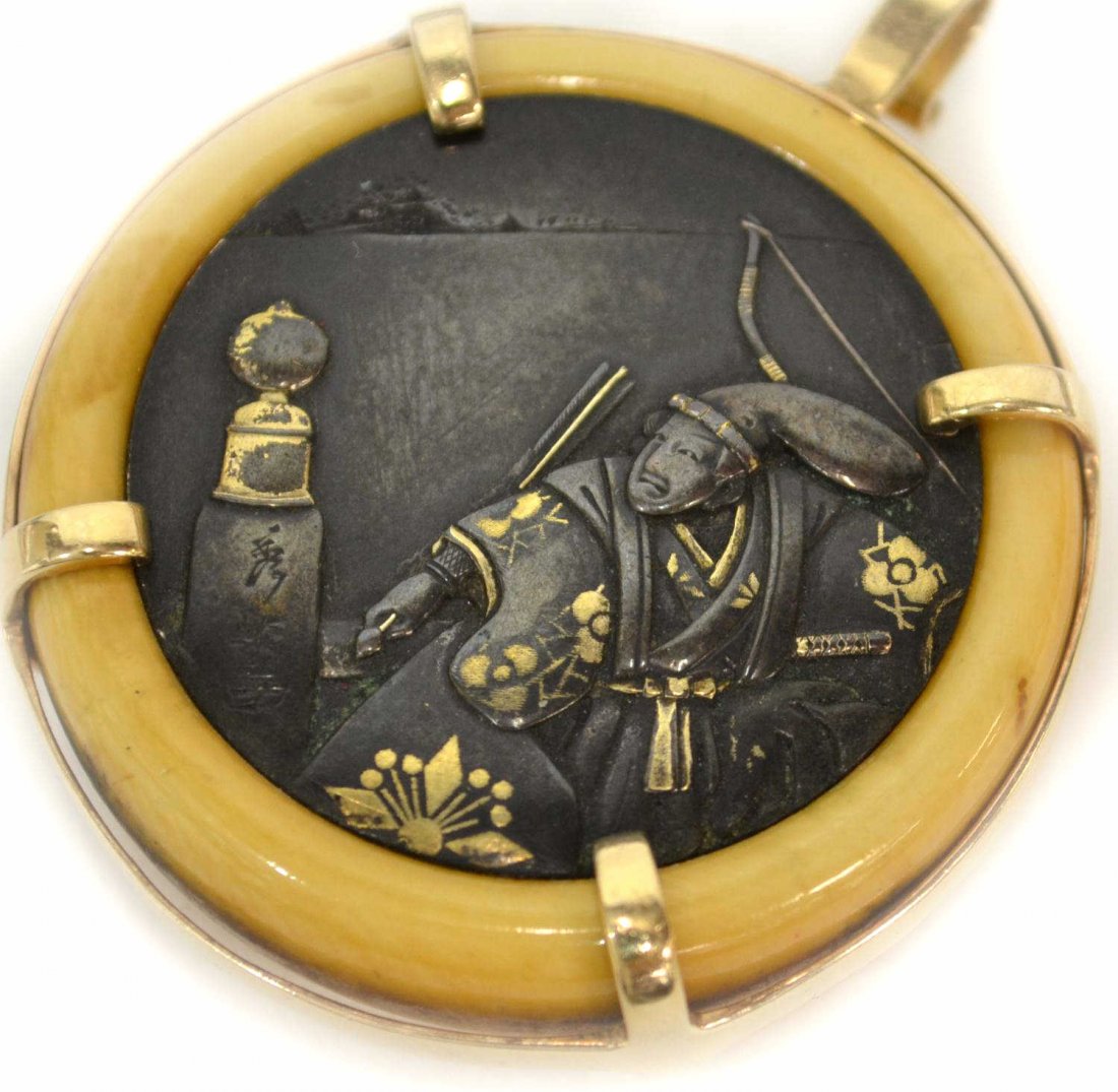 19TH C JAPANESE IVORY 14KT GOLD NETSUKE/ PENDANT: **International shipping is not available on this lot** Japanese ivory and mixed metal kagamibuta-style netsuke (now fashioned as a pendant with 14kt gold fittings), 19th century, the metal plate with