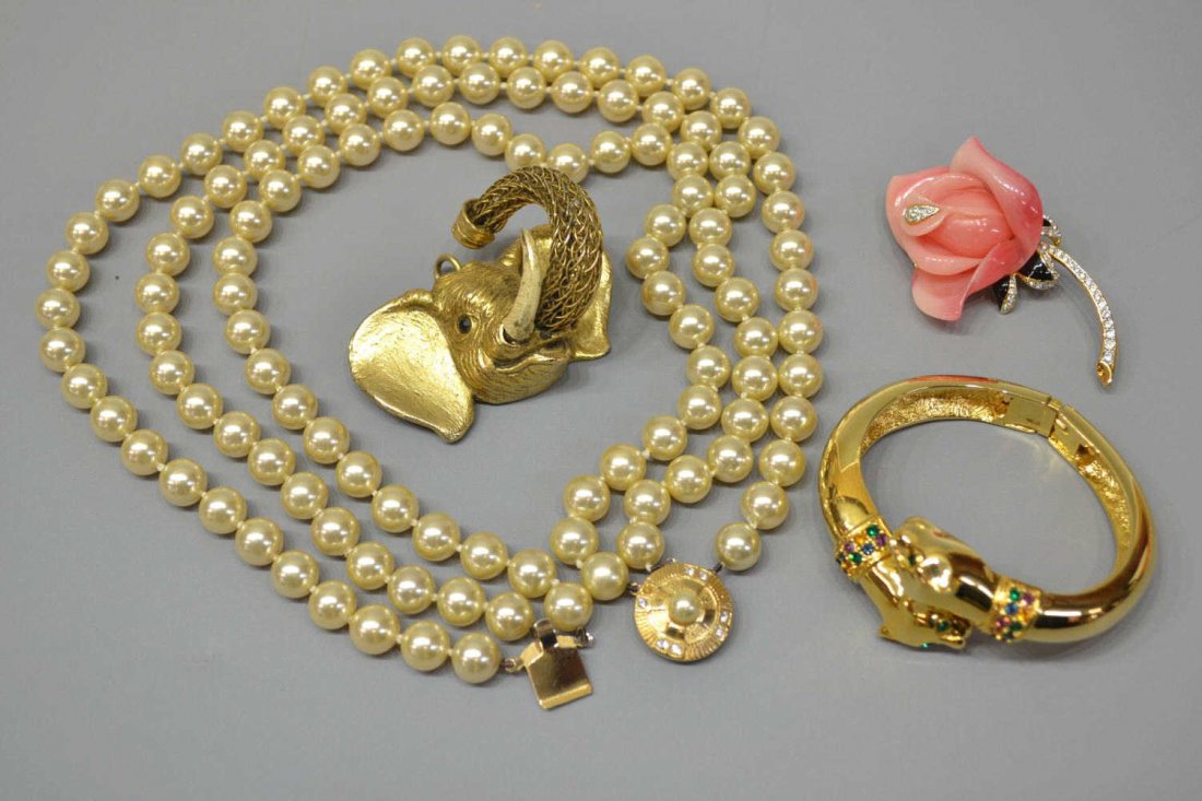 COLLECTION OF SIGNED COSTUME JEWELRY: (lot of 4) Costume jewelry group comprising: (1) gilt metal elephant pendant having openwork trunk, wear to enamel on tusks, faceted eye, 2"w; (1) Kenneth J Lane floriform brooch having black enamel a