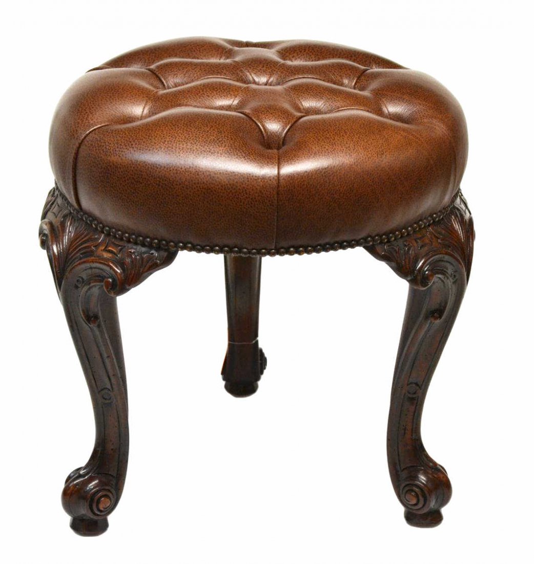 THEODORE ALEXANDER LEATHER STOOL: Theodore Alexander three leg stool with buttoned leather seat, foliate carved legs with scrolled feet, 20.75"h, 20"d **Provenance: Lou's Antiques and Fine Furnishings, Tulsa, OK** Start Price: $100.00