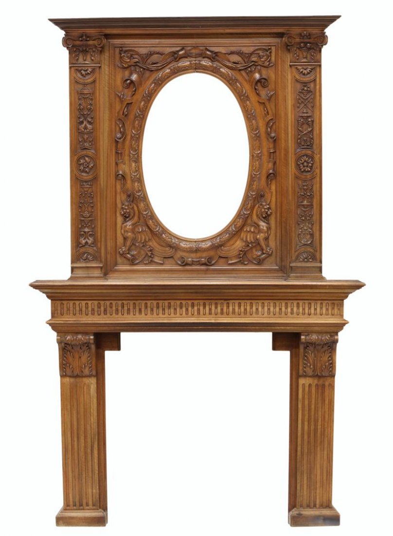 LARGE FRENCH ANTIQUE FIREPLACE SURROUND: Antique French two part walnut fire surround, 19th.c., the upper section with open area for oval mirror, painting or decorative addition, surrounded by carved foliate, mask and winged griffin carving,