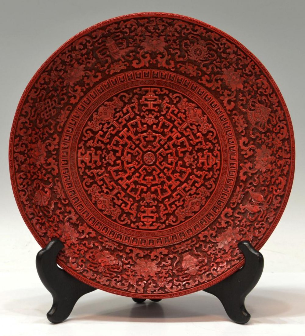 CHINESE CARVED CINNABAR PLATE: Chinese carved cinnabar plate, carved with scrolling clouds and foliates, marked underfoot as pictured, 2"h, 11.5"diam, 1lb Start Price: $100.00