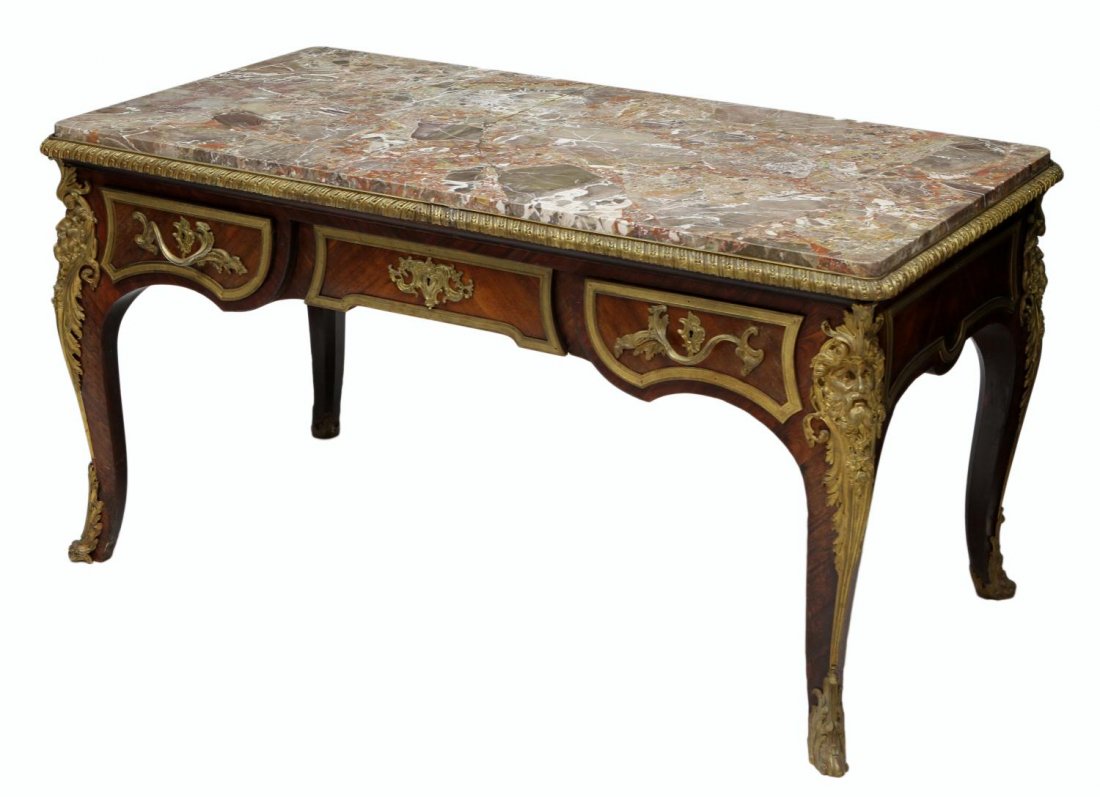FRENCH LOUIS XV STYLE GILT BRONZE MARBLE TOP DESK: Louis XV style marble top bureau plat, 19th c., a faux partners desk having thick marble top, set over the base with foliated gilt bronze mountings and detailed figural masks, three actual drawers to 