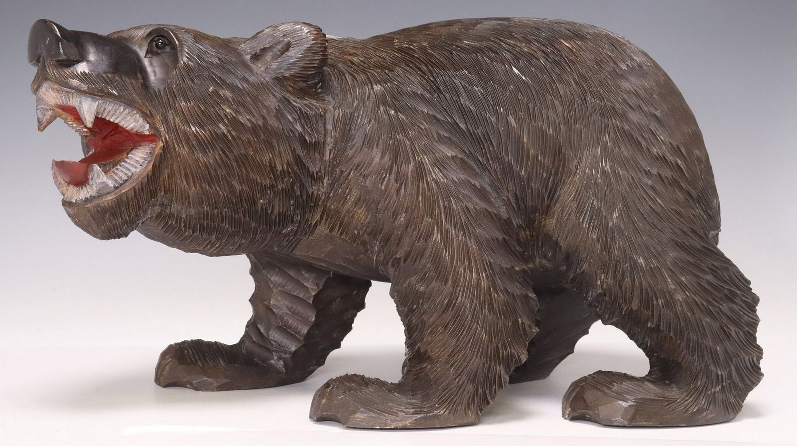 BLACK FOREST STYLE CARVED WOOD FIGURAL BEAR SCULPTURE: Black Forest style carved wood figural bear sculpture, late 19th c., modeled as a standing bear with mouth agape, inset glass eyes and articulated fur, painted decoration to mouth interior, approx 9&q
