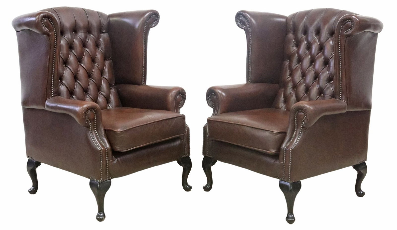 (2) BRITISH THOMAS LLOYD 'CANTERBURY' LEATHER WINGBACK ARMCHAIRS: (pair) British "Canterbury" highback armchairs, Thomas Llyod, 21st c., each in brown button-tufted leather upholstery, with nailhead trim, removable seat cushion, rising on cabriole legs, en