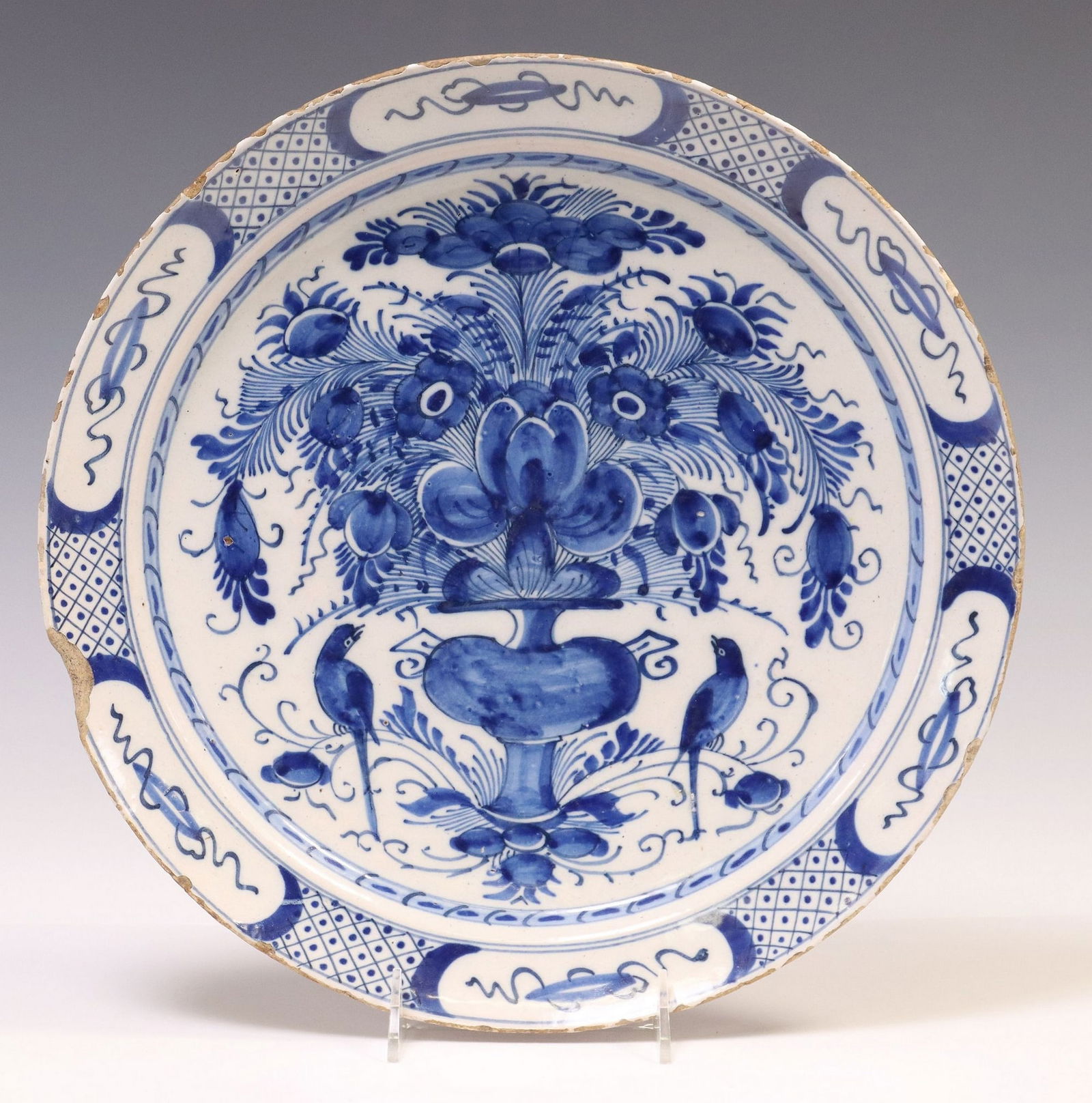 DELFT BLUE & WHITE TIN-GLAZED FLORAL URN & BIRDS CHARGER: Delft tin-glazed earthenware charger, late 18th c., central well with abundant flower basket and perched birds, left side with rim chip, typical small rim chips, and glaze loss, approx 13.5"diam,