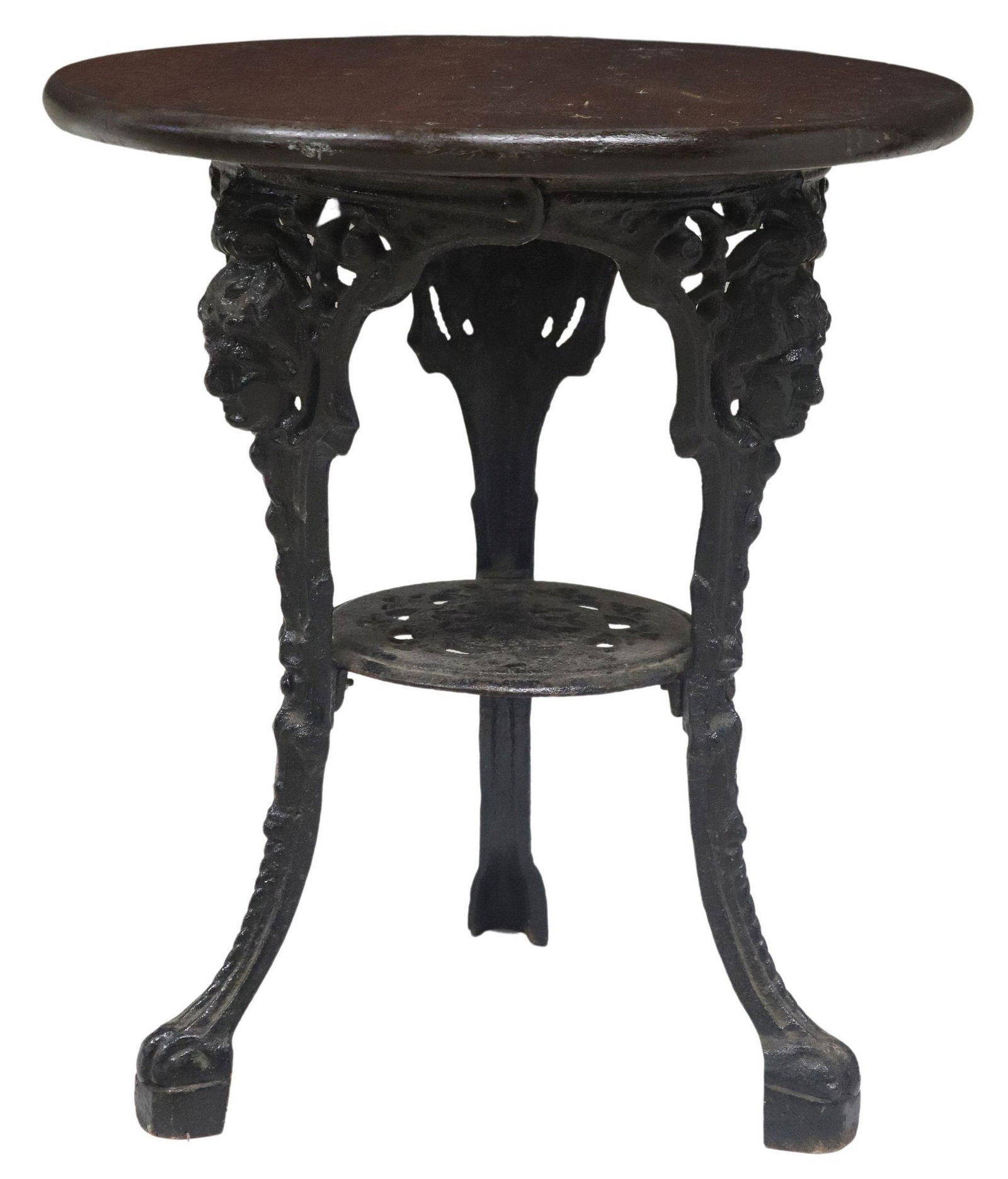 ENGLISH OAK & CAST IRON PUB TABLE: English pub table, 20th c., round oak tabletop, rising on cast iron base, three legs with classical masks, joined by medial shelf, in a black painted finish, finish loss to top, approx 26.5"