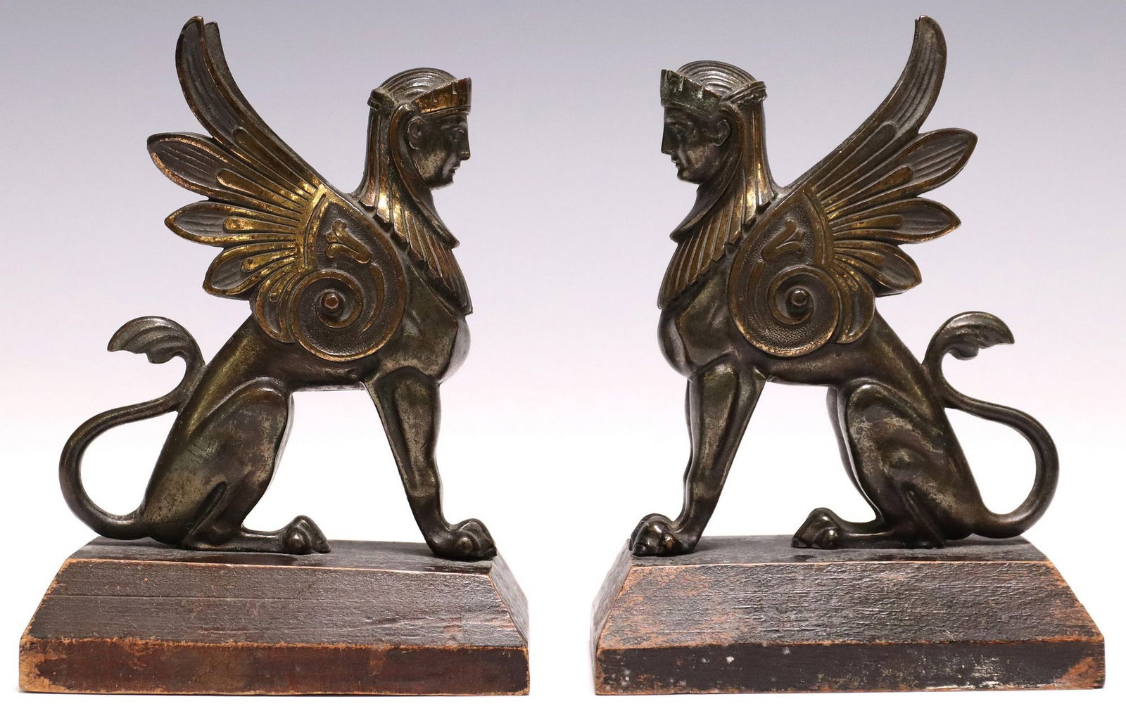 (2) NEOCLASSICAL-STYLE PATINATED BRONZE FIGURES SEATED SPHINX: (pair) Neoclassical-style patinated bronze sphinx figures, each in seated pose with raised wings, rising on integral wood base, approx 6.25"h, 4.5"w, 2.75"d, 2.5lbs total