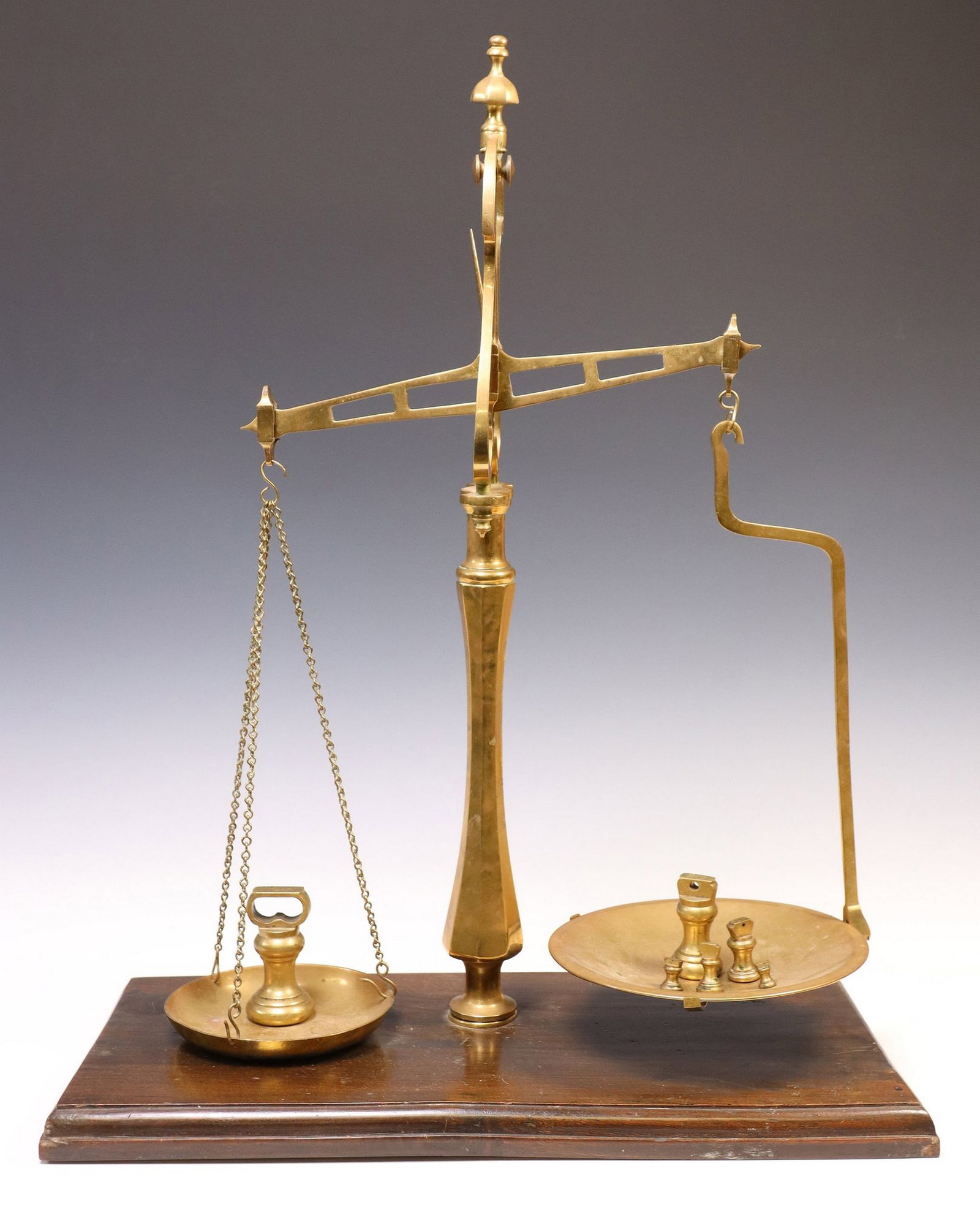 ENGLISH 'LIBRASCO' CAST IRON & BRASS BALANCE SCALES: English cast iron and brass balance scales, early 20th c., balance beam supporting two varied pans, rising on wood base, stamped "Librasco," accompanied by (6) graduated weights from 1/