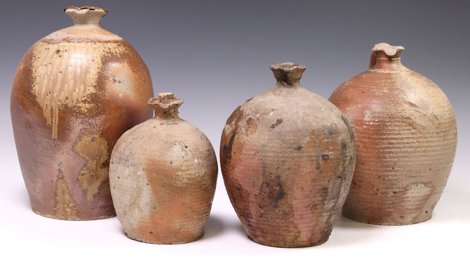 (4) FRENCH PROVINCIAL STONEWARE OIL JUGS: (lot of 4) French Provincial stoneware oil jugs, each having tapered body, pour spout, and single handle to one side, (two) with glaze remnants, largest: approx 13.5"h, 9.5"diam, 24lbs total