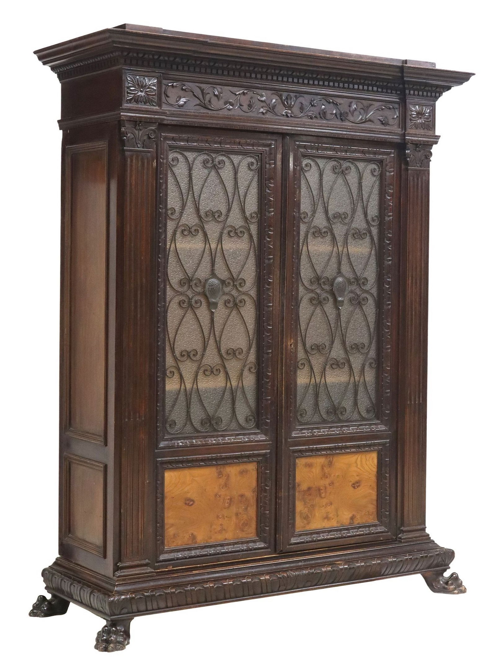 RENAISSANCE REVIVAL MAHOGANY & WROUGHT IRON BOOKCASE: Italian Renaissance Revival mahogany bookcase, early 20th c., having molded cornice, over carved foliated scrolls, dual glazed doors with molded glass and scrolled wrought iron overlay centering
