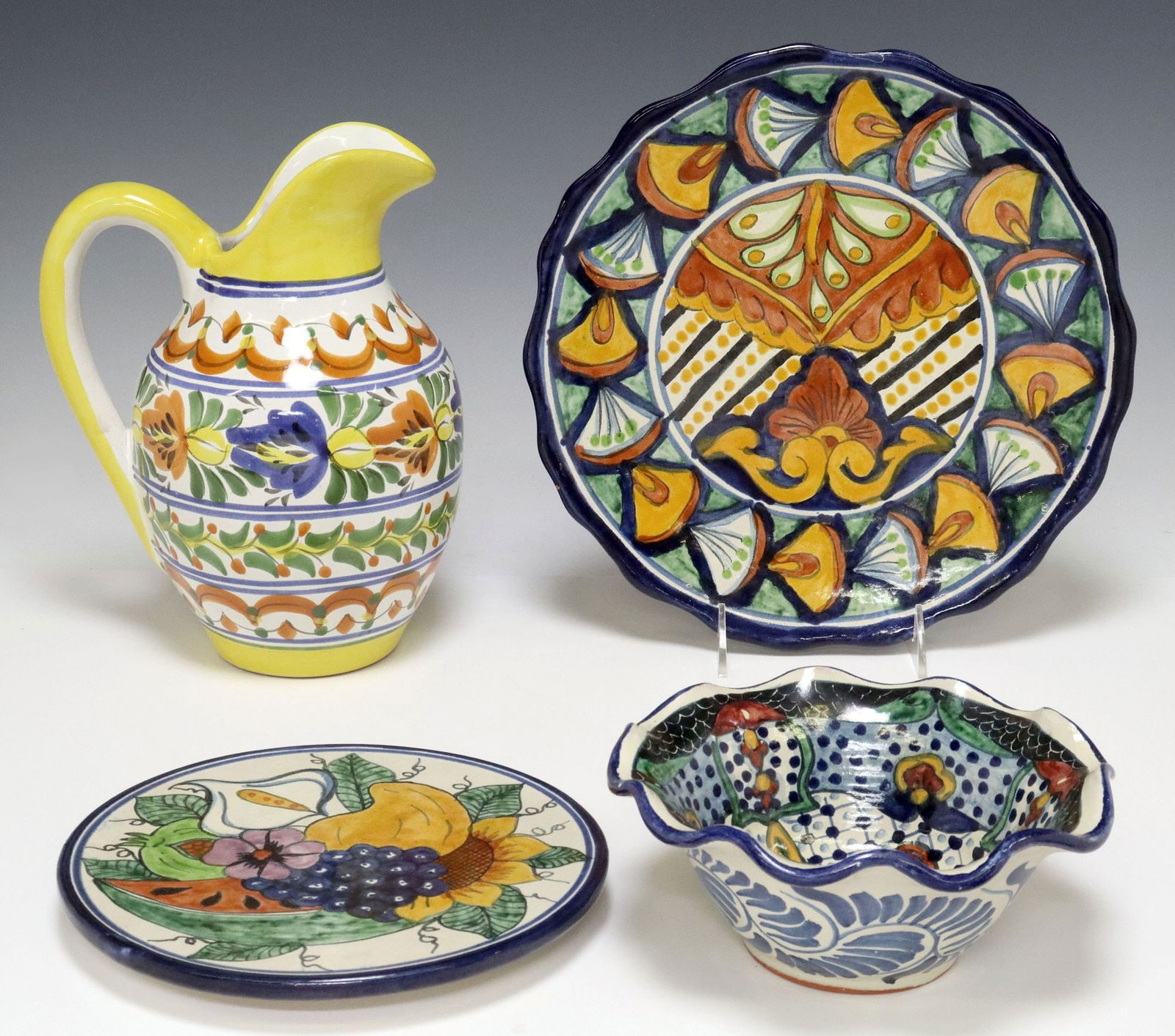 (4) TALAVERA POTTERY TABLE ARTICLES, MEXICO: (lot of 4) Talavera pottery, Mexico, including: (1) pitcher, approx 9.75"h, (1) deep bowl with ruffled rim, approx 3"h, 7.25"diam, (1) round trivet, approx 8"diam, (1) charger