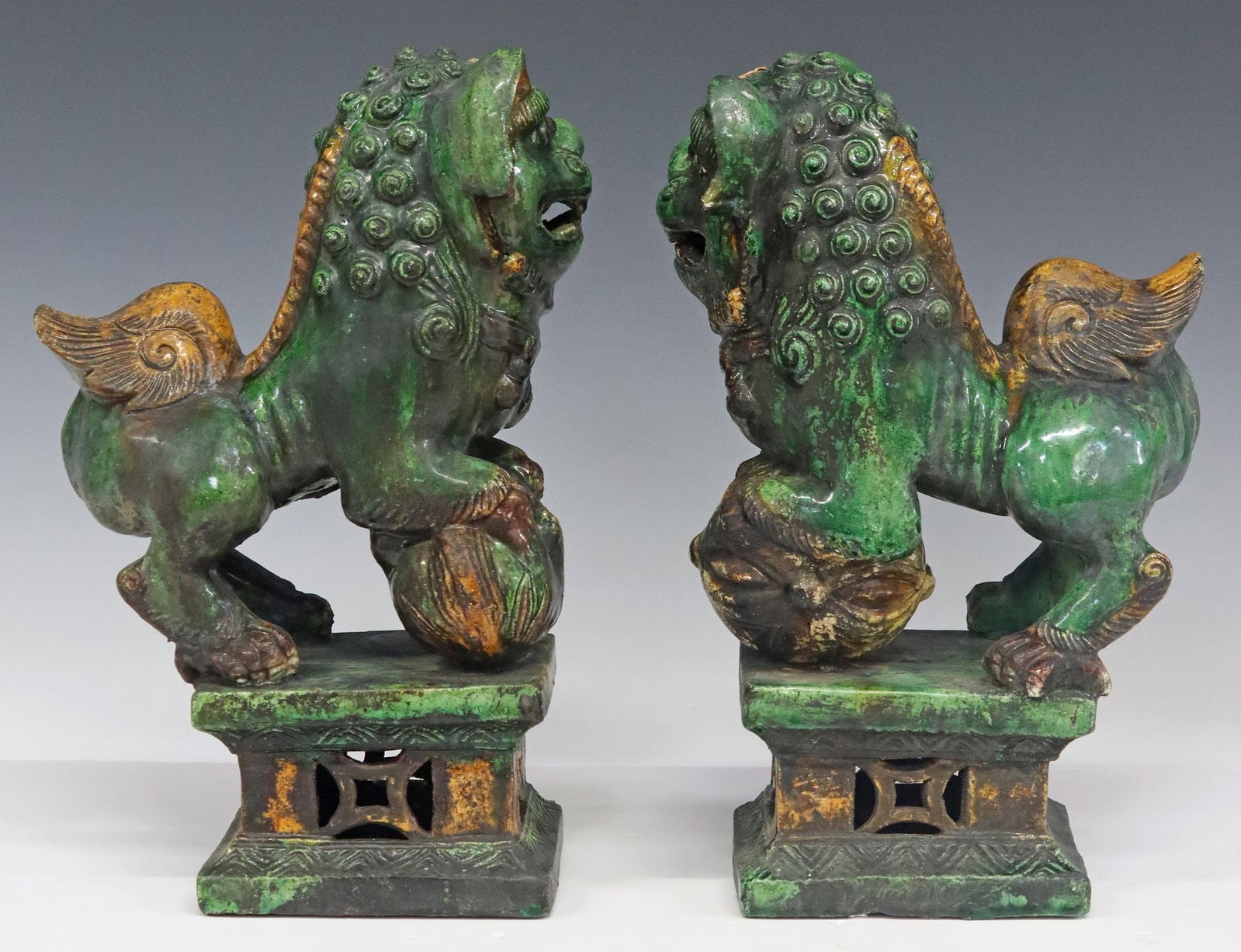 (2) CHINESE SANCAI PALETTE GLAZED FOO LION CENSERS: (lot of 2) Chinese glazed foo lion censers/ incense burners, in a Sancai palette, one with ball and one with cub under its paw, rising on pedestal bases, largest: approx 13.5"h, 7"w, 4.5&quo