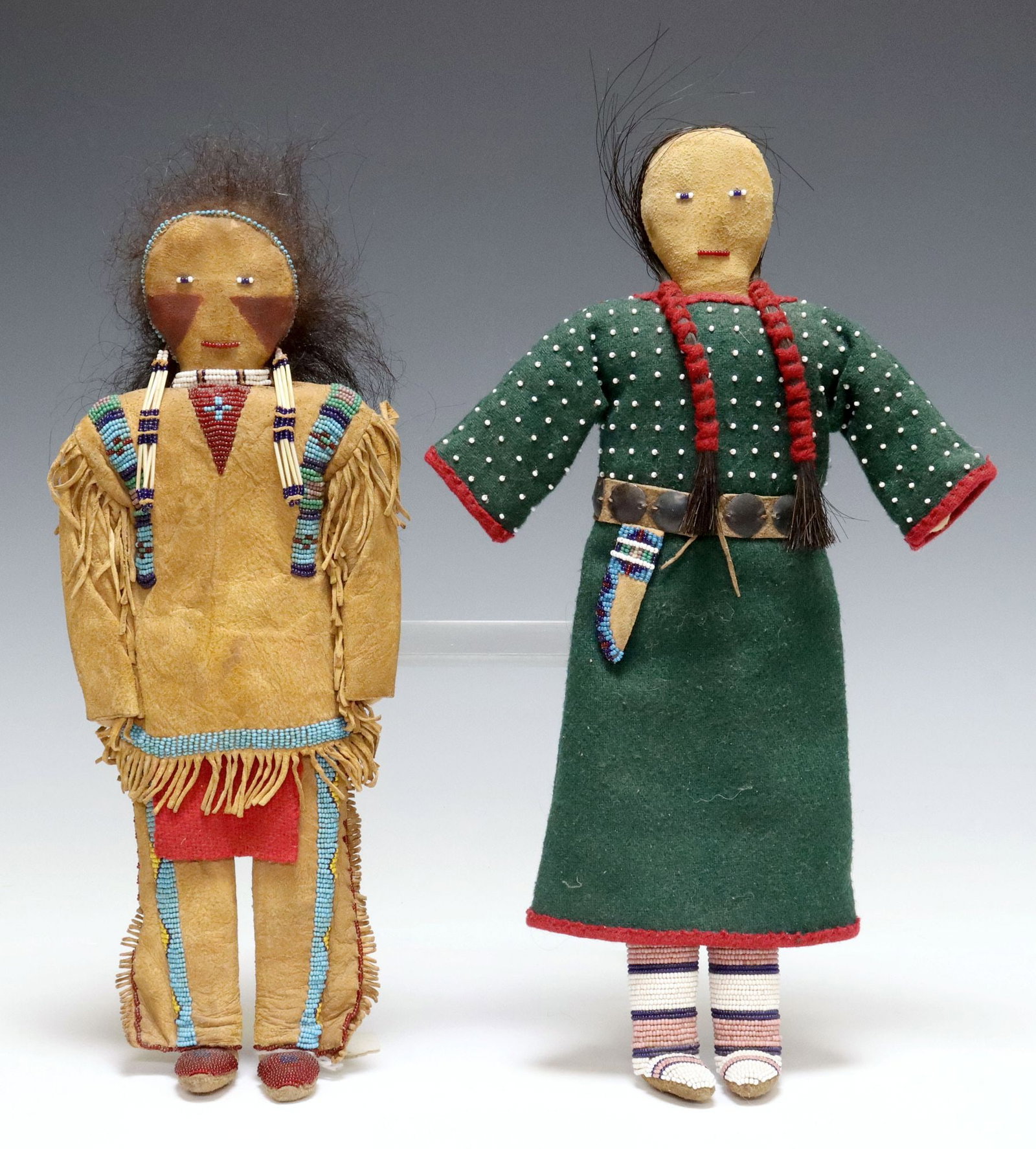 (2) NATIVE AMERICAN STYLE HAND-SEWN & BEADED SUEDE DOLLS: (lot of 2) Native American style dolls, each wearing beaded garments and accessories, with applied hair and facial features, including: (1) male doll, in fringed suede ensemble with painted face, appr