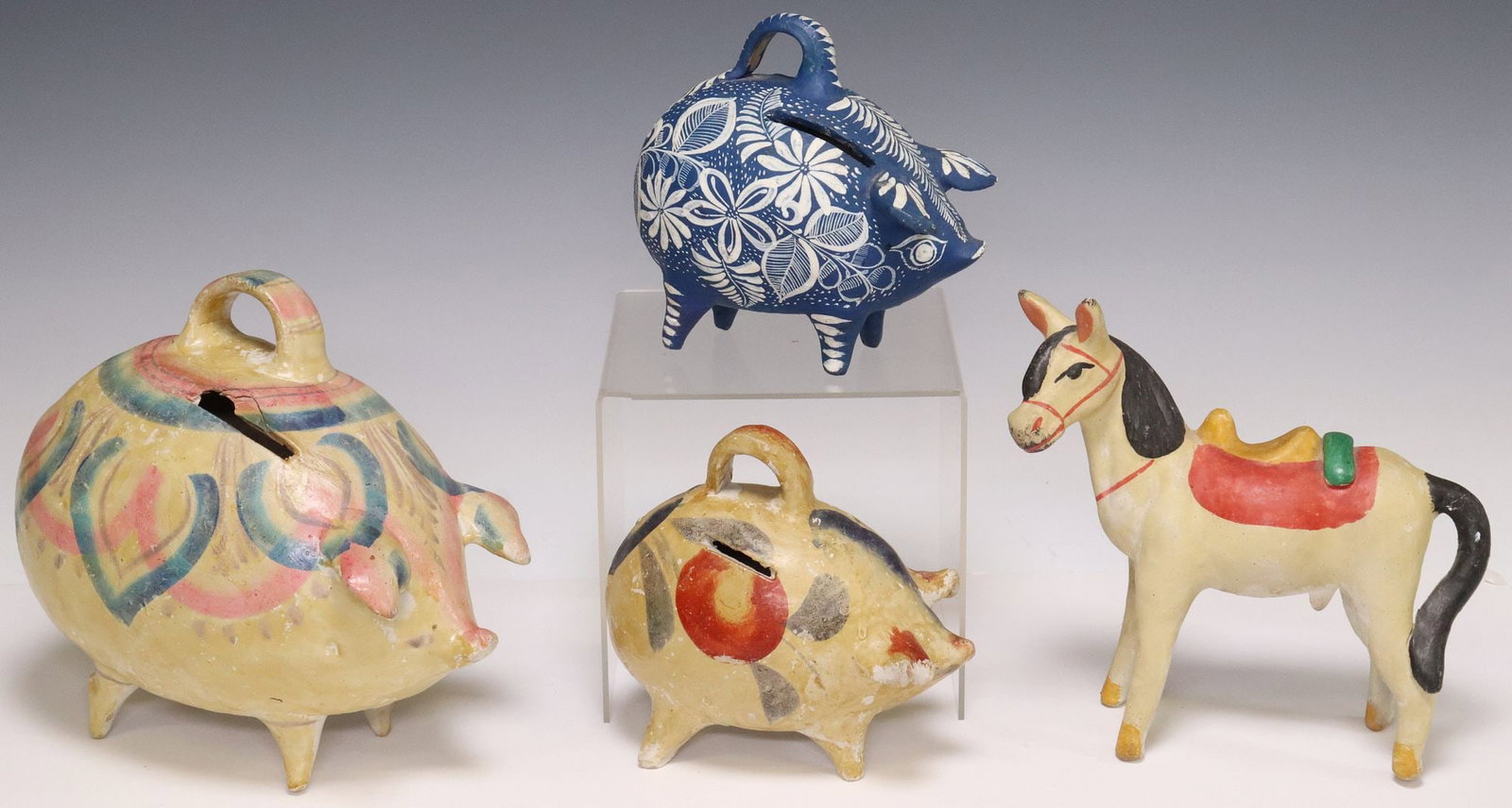 (4) TLAQUEPAQUE MEXICO POTTERY FIGURAL COIN BANKS: (lot of 4) Tlaquepaque pottery figural coin banks, Jalisco, Mexico, c. 1930s, including: (3) pig-form banks, central strap handle, (one) with hand-painted scrolling florals on navy ground; (1) bu