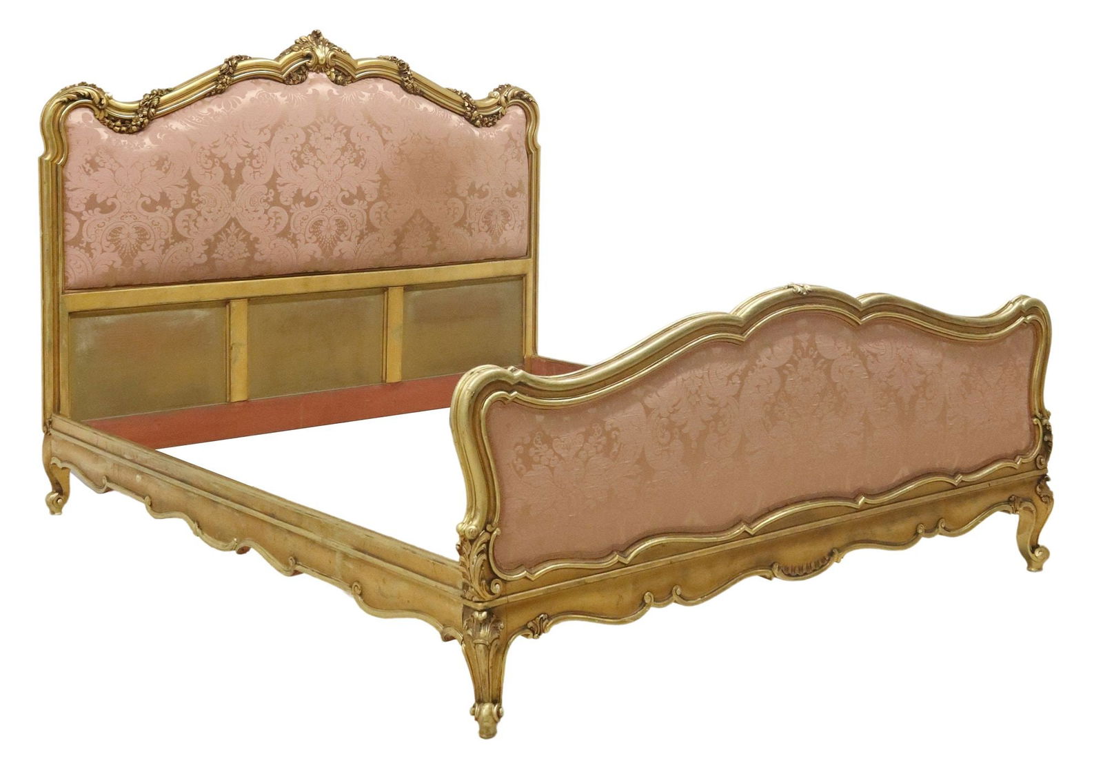 ITALIAN LOUIS XV STYLE SILK-UPHOLSTERED GILTWOOD BED: Italian Louis XV style giltwood bed, 20th c., having fanned crest, over shaped headboard with molded floral swag, headboard and footboard in patterned pink damask silk upholstery, joined by scalloped
