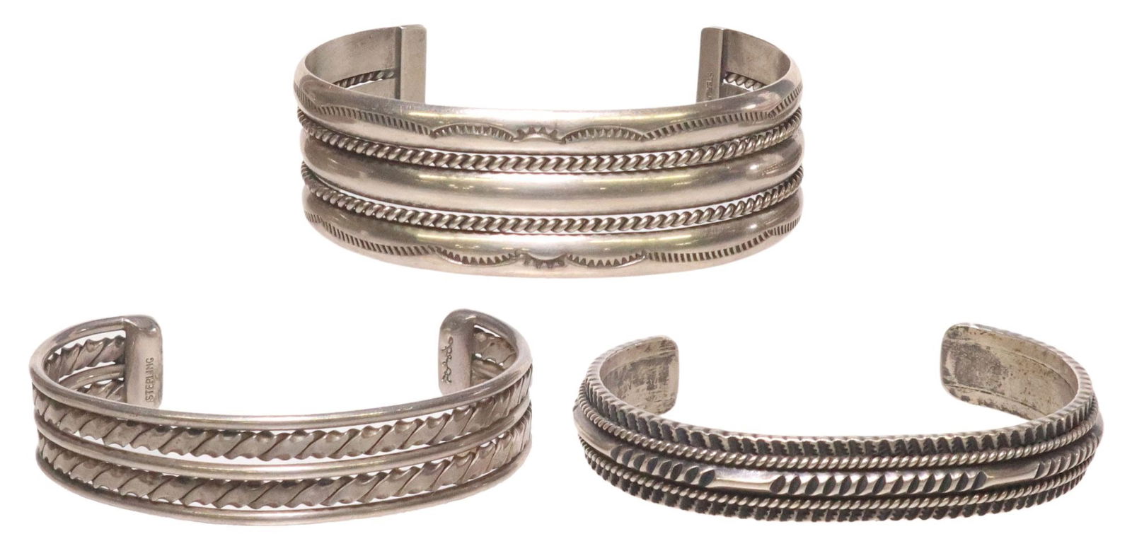 (3) NATIVE AMERICAN STERLING SILVER CUFF BRACELETS: (lot of 3) Native American sterling silver cuff bracelets, including: (1) wide cuff, Nora Tahe (Navajo/ Dine, 20th c.), twisted wire rope, stamp work designs, approx 7/8"w, interior: approx