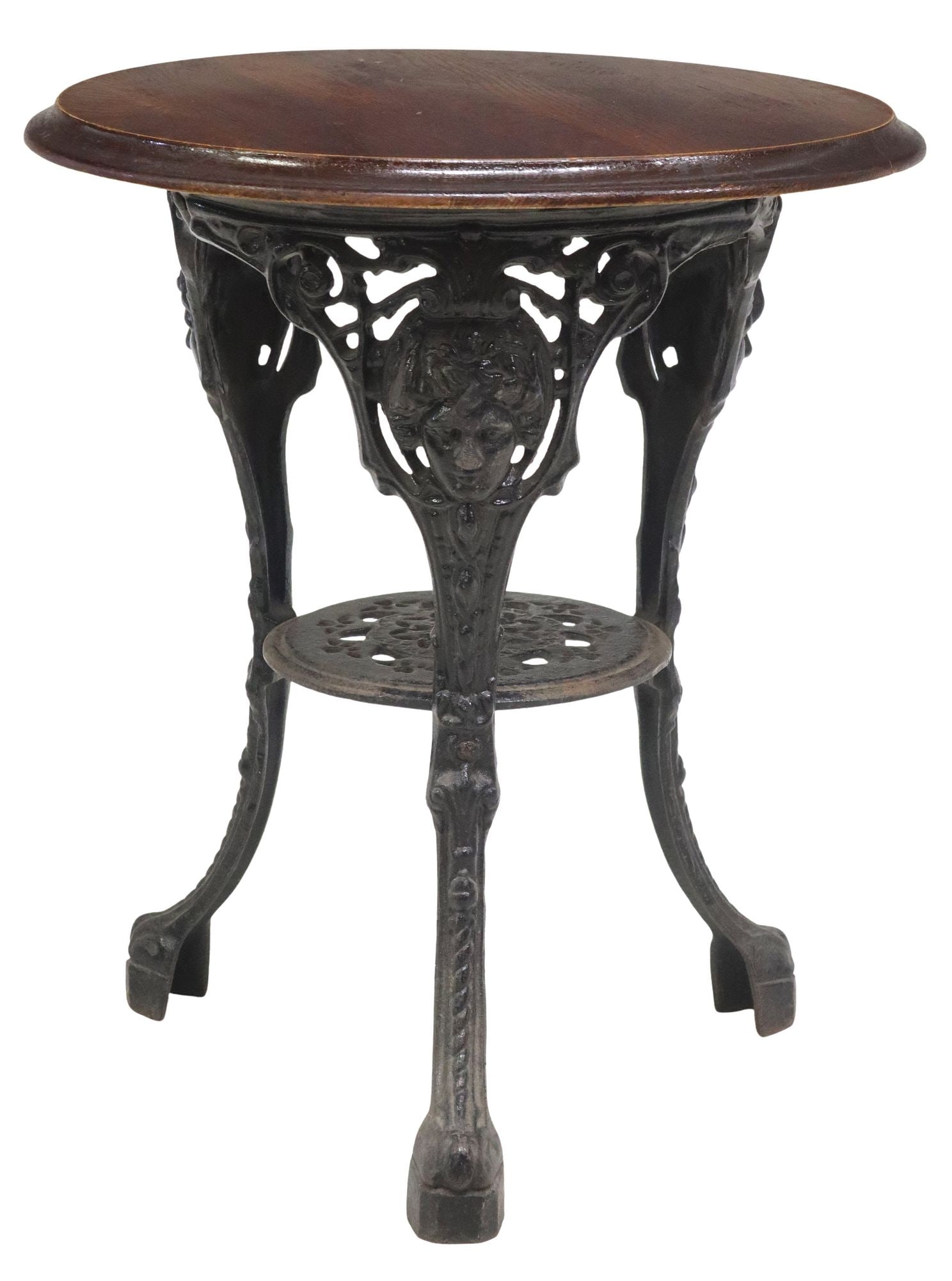 ENGLISH OAK & CAST IRON PUB TABLE: English pub table, 20th c., having round oak tabletop, cast iron base, three legs with classical masks, joined by medial shelf, approx 27.5"h, 23.5"diam
