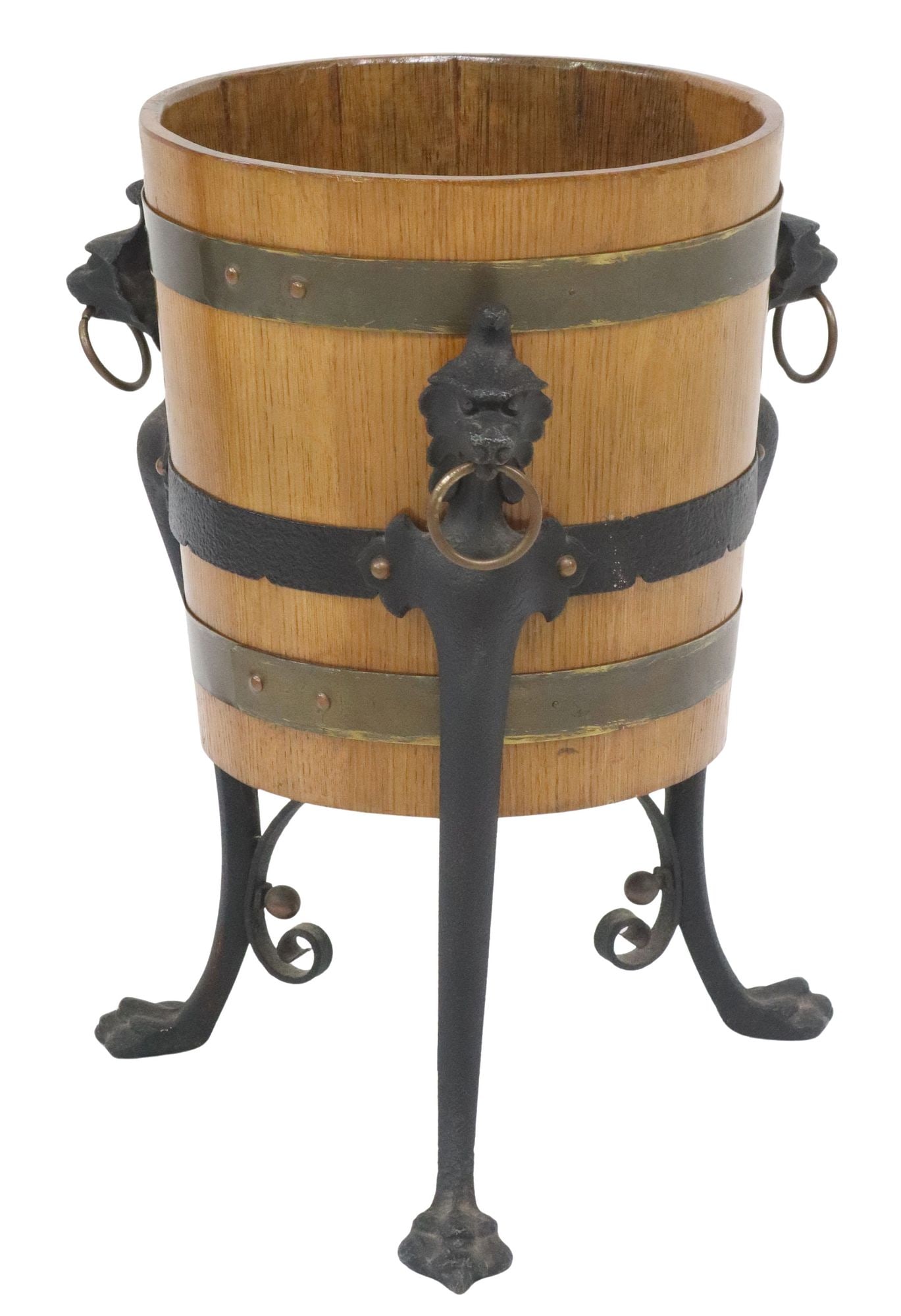 ENGLISH OAK BARREL-FORM PLANTER ON FIGURAL IRON STAND: English oak barrel-form standing jardiniere/ planter, late 20th c., brass-bound barrel, rising on cast iron grotesque supports with ring handles, ending on paw feet, approx 22"h, 17.5"w, 17.